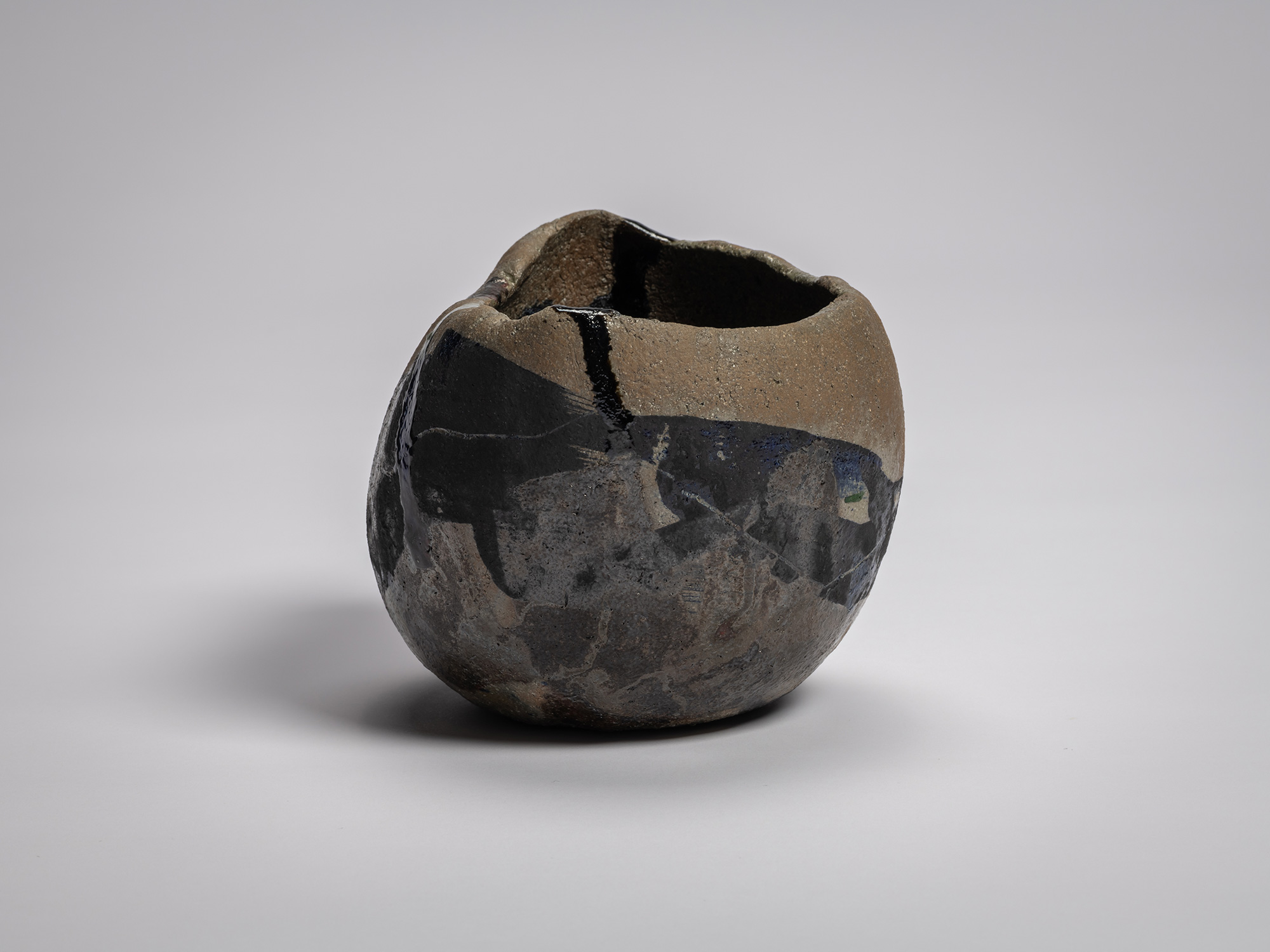 Side view of Raku XV tea bowl Hekikai Mugen (“Infinite Profound Blue”) highlighting its compressed,...
