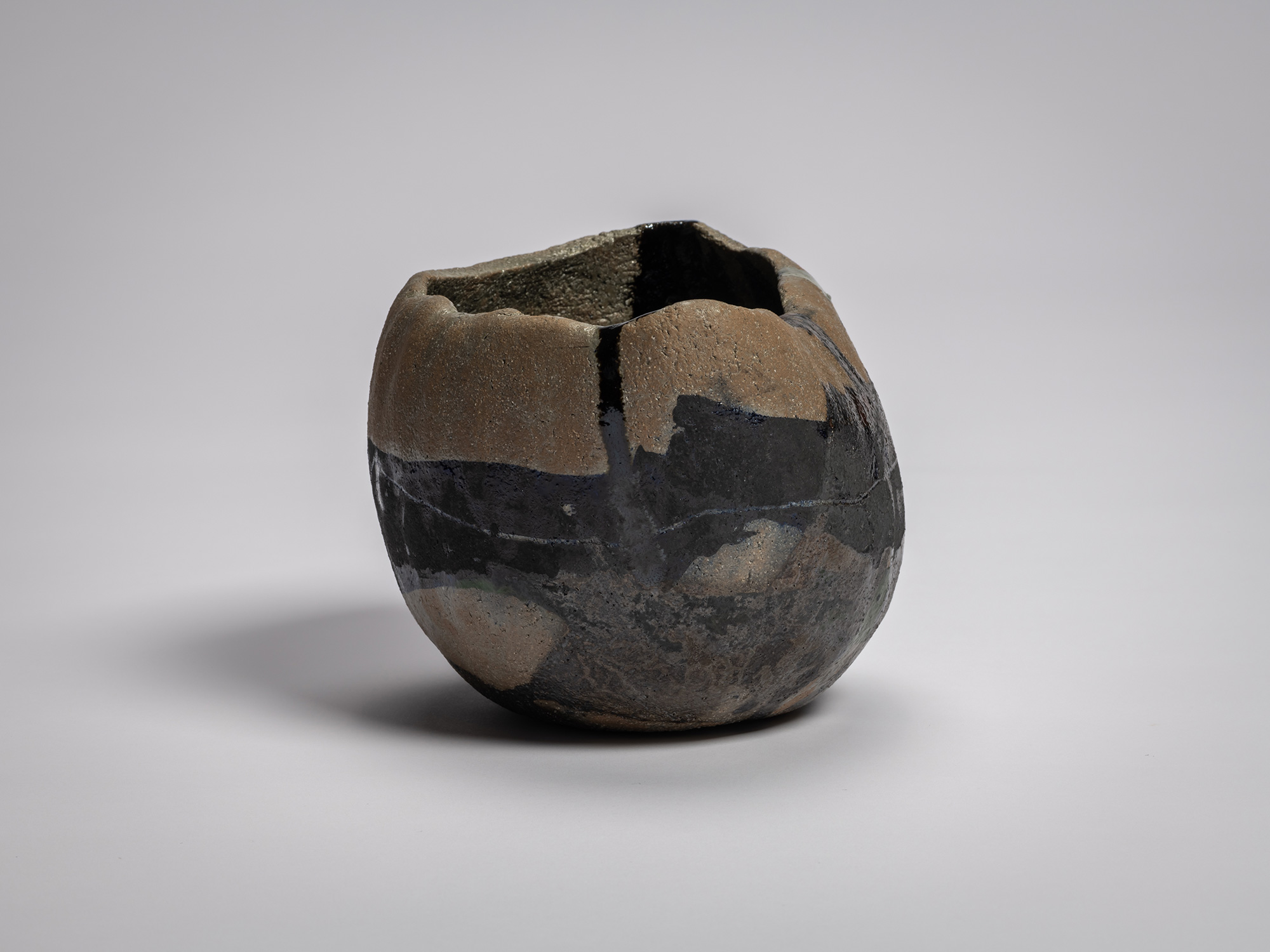 Side view of Raku XV tea bowl Hekikai Mugen (“Infinite Profound Blue”) highlighting its compressed,...