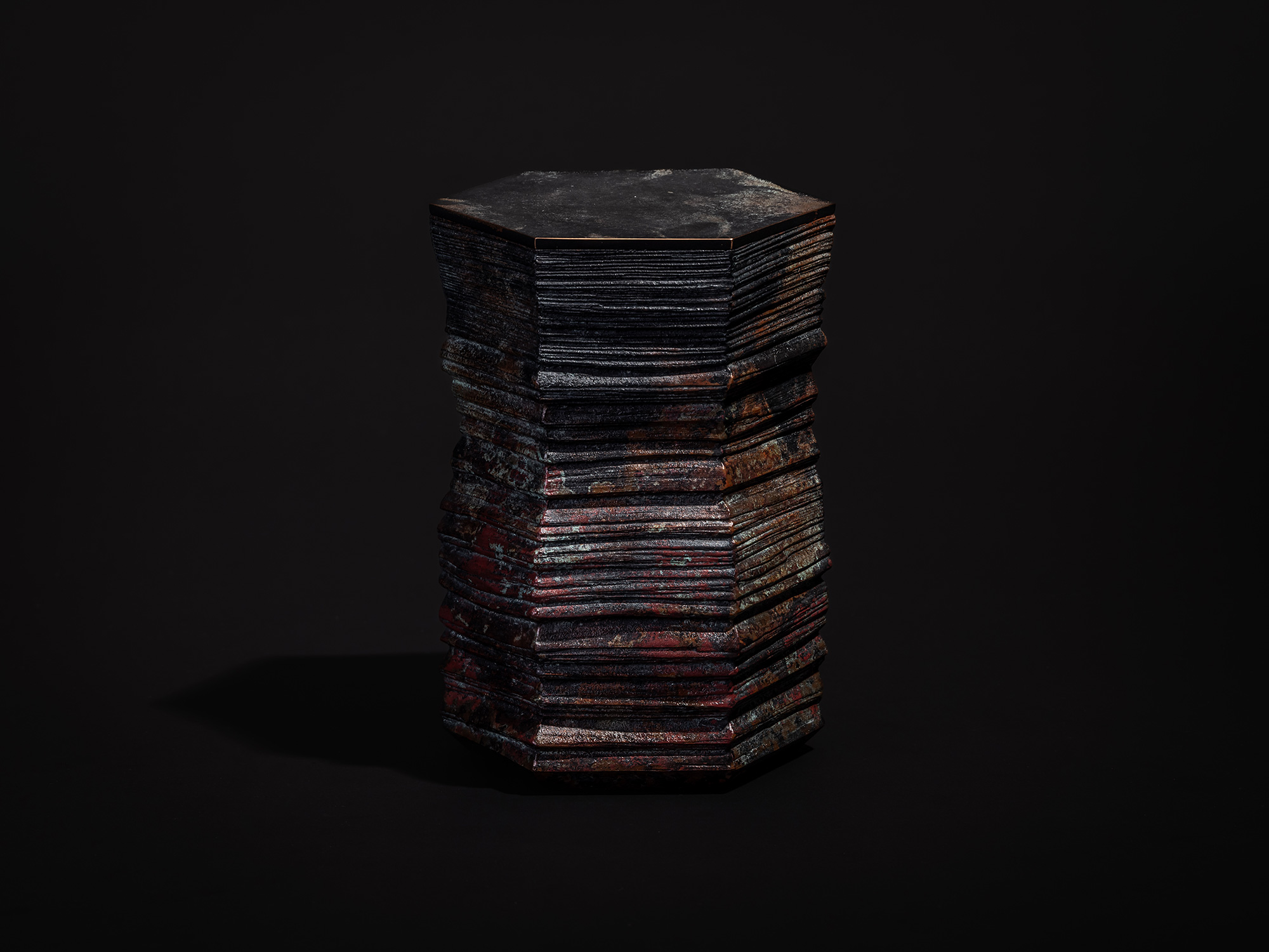 Hexagonal bronze sculpture titled Hexagonal Strips by Koji Hatakeyama, formed from tightly stacked...