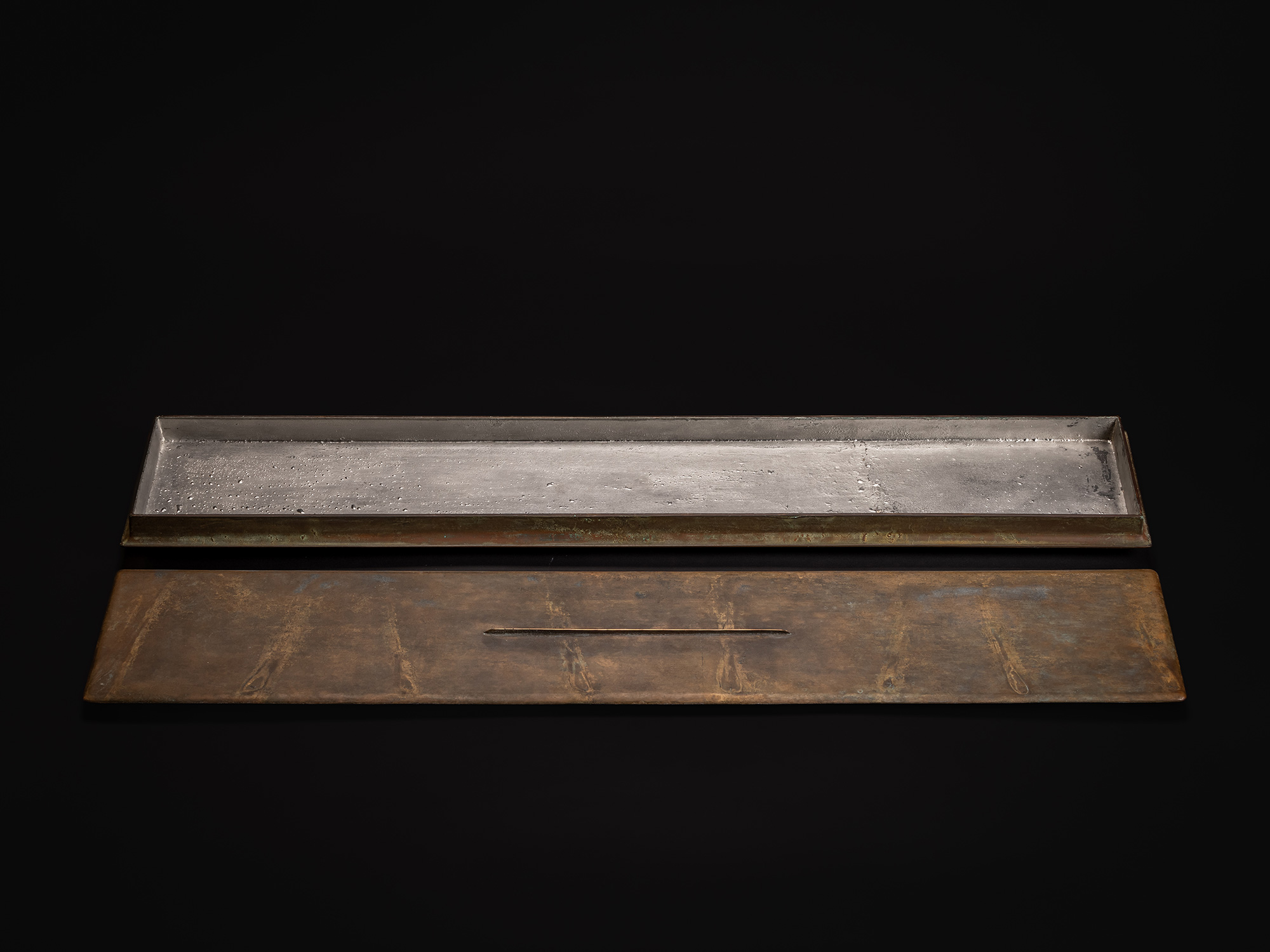 Rectangular bronze sculpture by Koji Hatakeyama shown with the lid removed. The long, low bronze...
