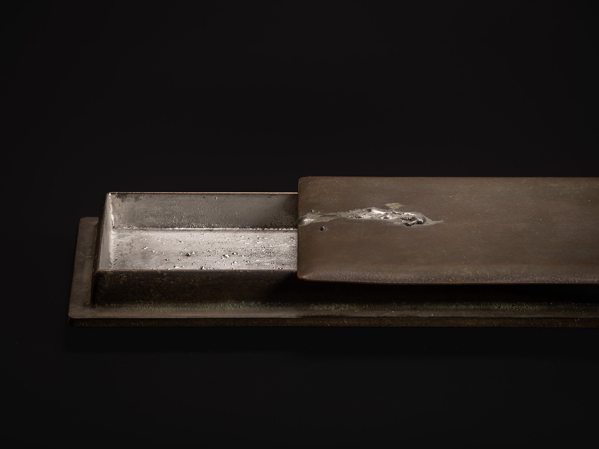 Detail view of Sideways Bronze by Koji Hatakeyama, showing the bronze lid slid open to the left,...