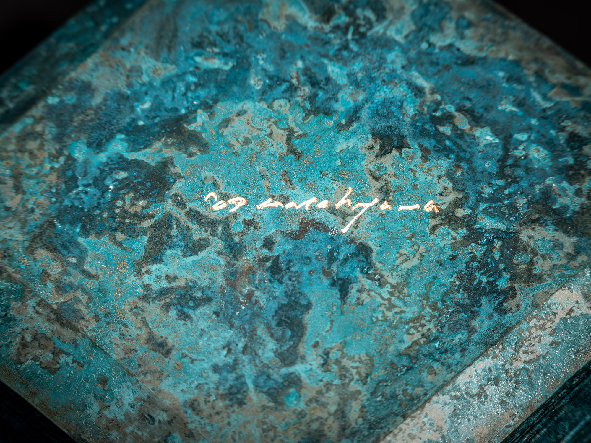 Close-up of the artist’s signature incised into the bottom of the bronze box Square Strips by Koji...