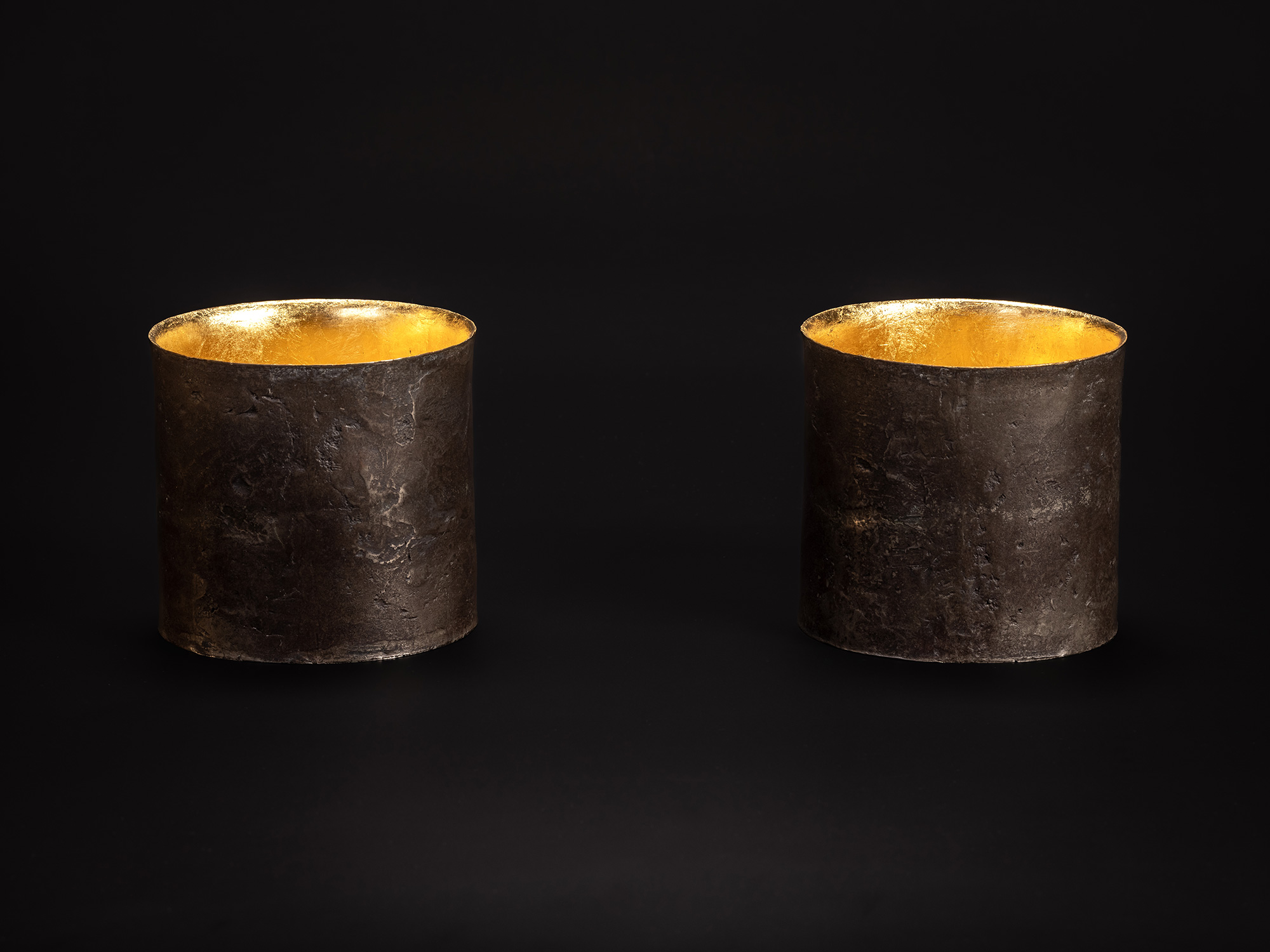 Two Cylinders by Koji Hatakeyama, showing a pair of cylindrical bronze vessels with dark, weathered...