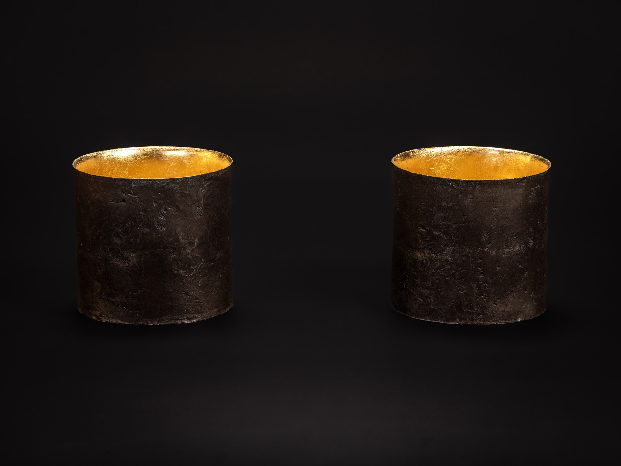 Two Cylinders by Koji Hatakeyama, showing a pair of cylindrical bronze vessels with dark, weathered...