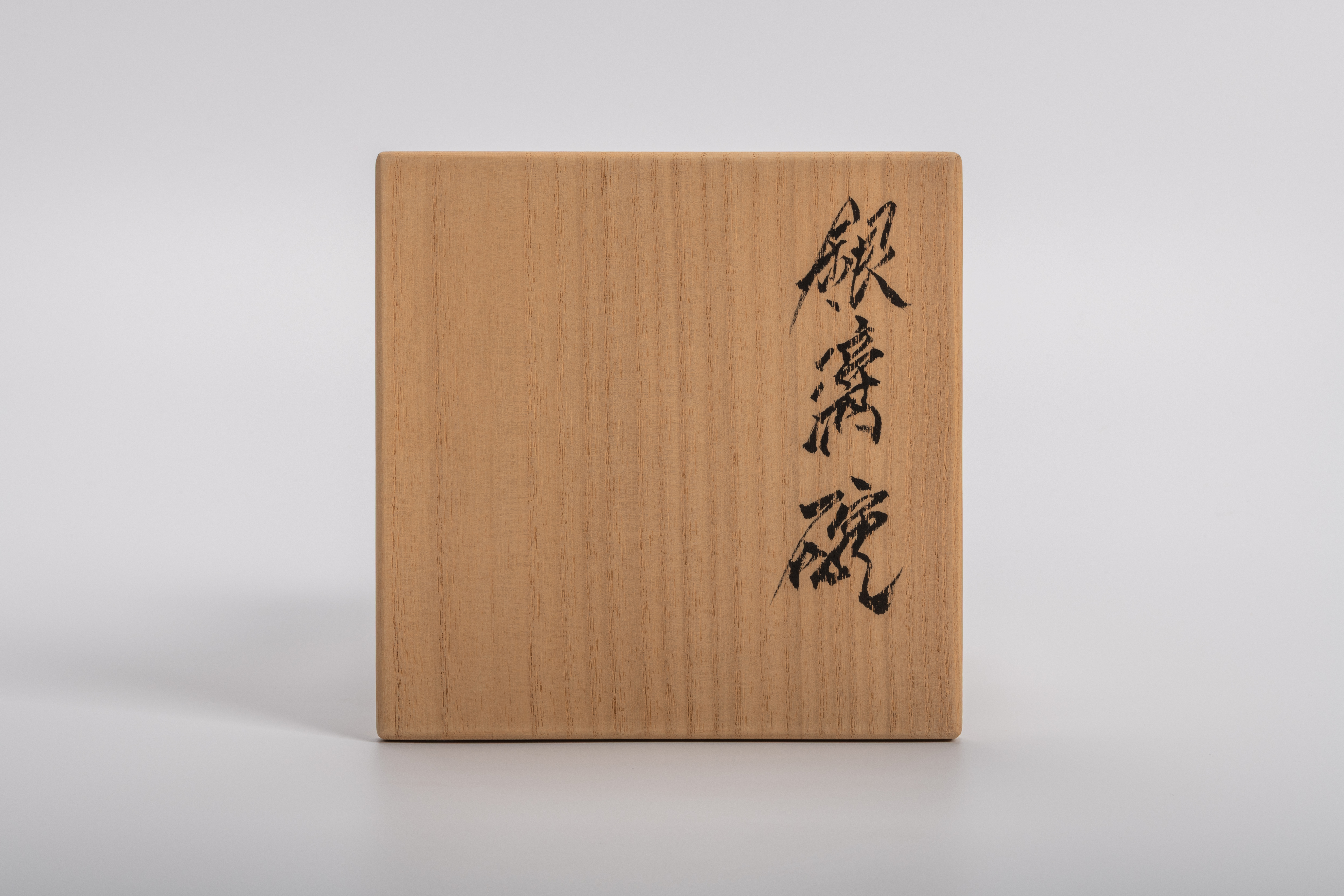 Exterior lid of wooden tomobako for Takahiro Kondo “Wave Bowl: Tsunami,” inscribed in bold black...