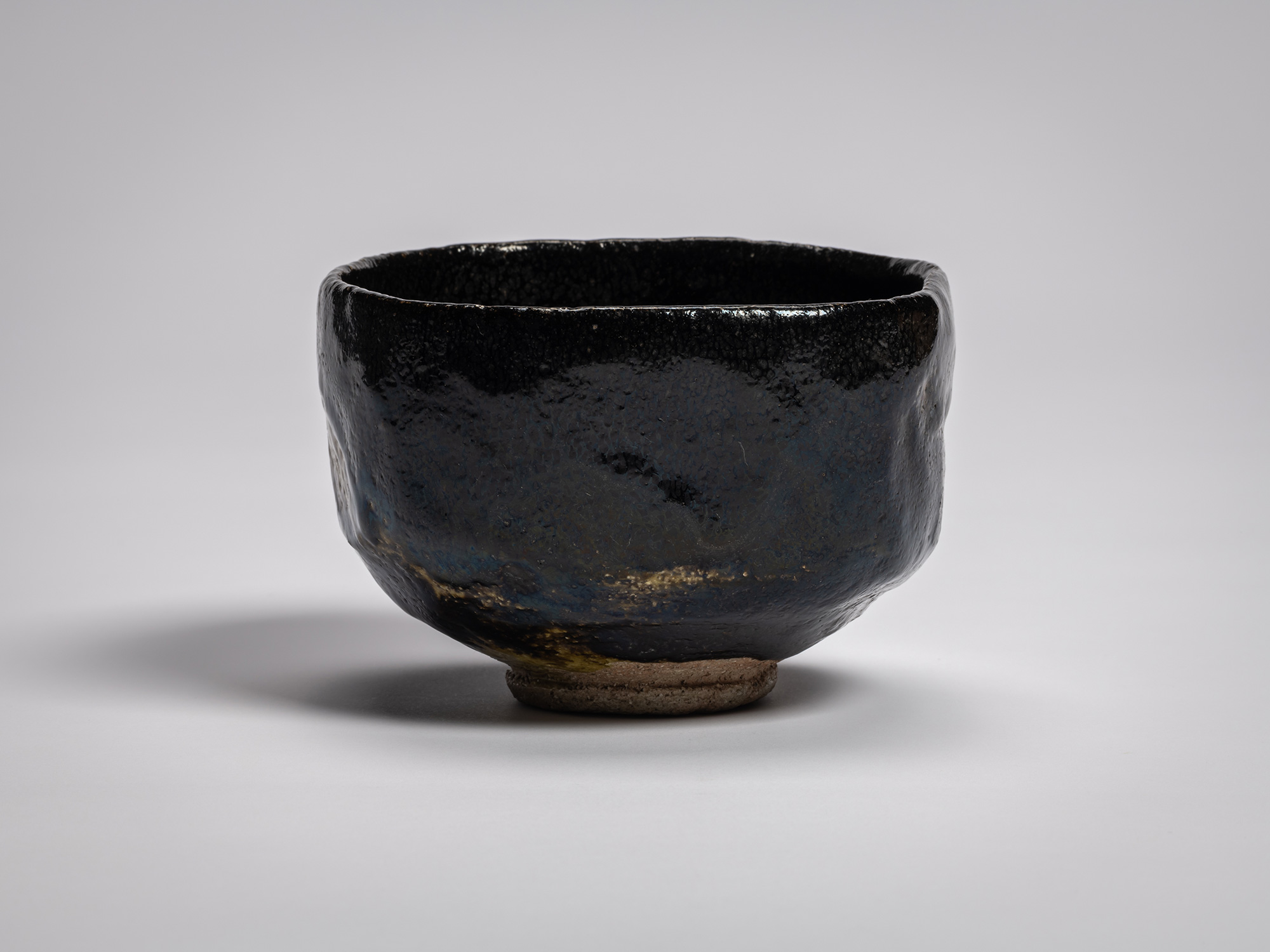 Black Raku tea bowl Yōbō Shungen by Raku IX, featuring a compact, softly faceted form with a gently...