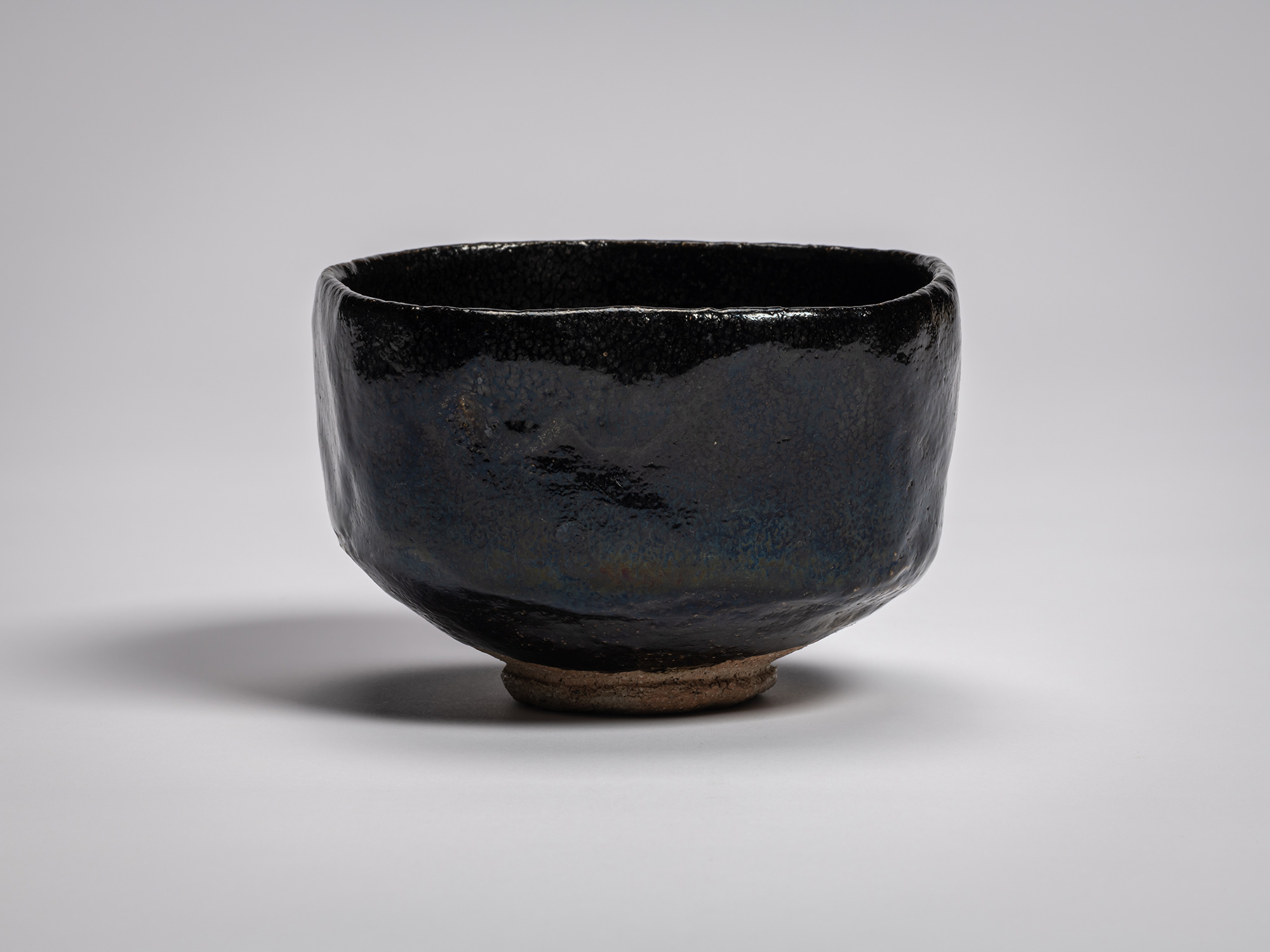 Black Raku tea bowl Yōbō Shungen by Raku IX, featuring a compact, softly faceted form with a gently...