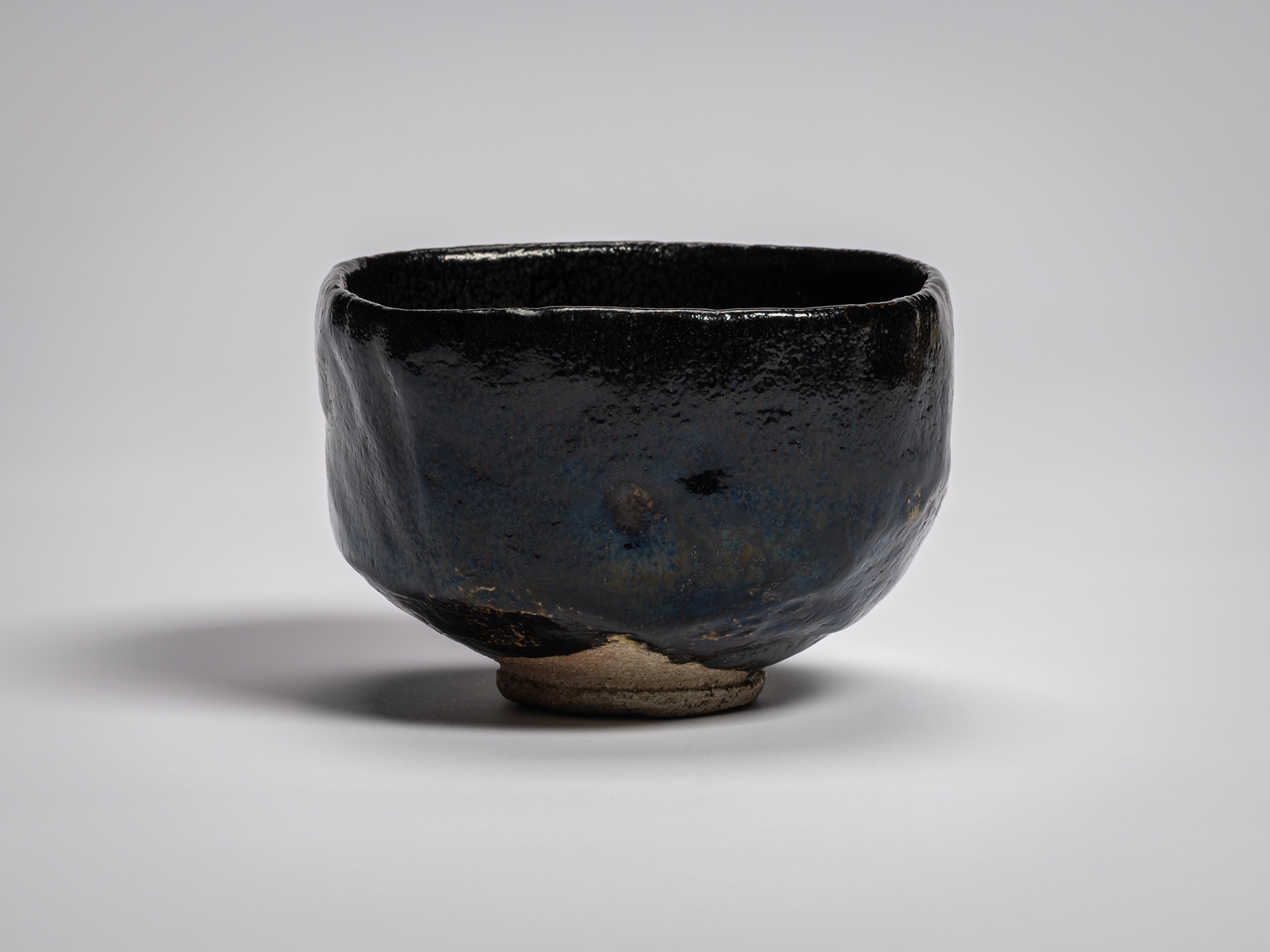 Black Raku tea bowl Yōbō Shungen by Raku IX, featuring a compact, softly faceted form with a gently...