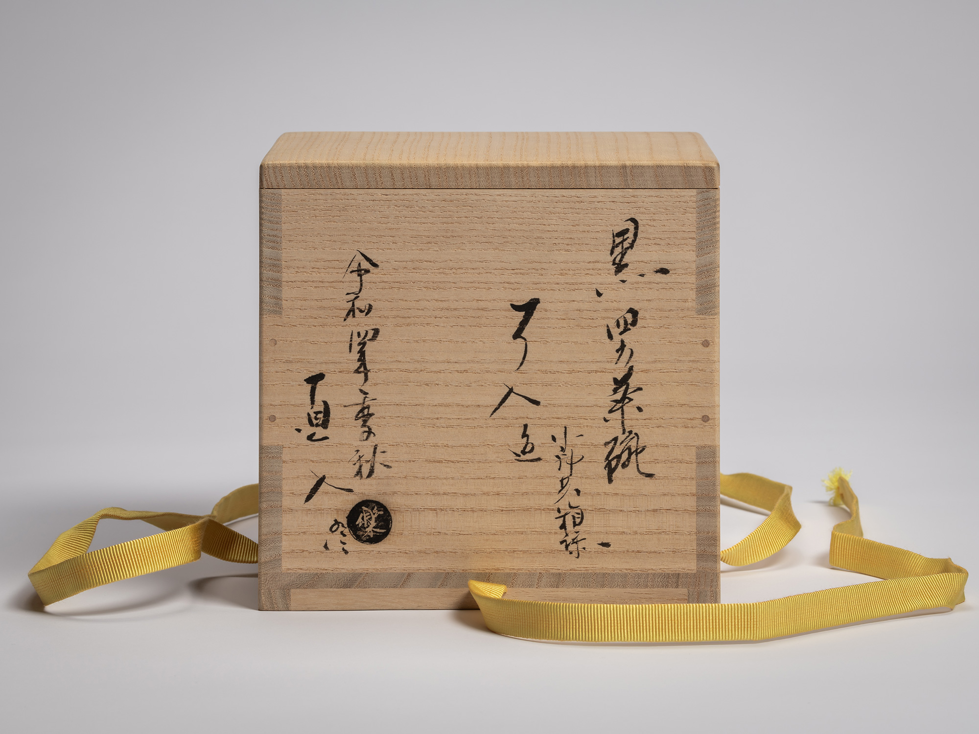 Front face of the wooden storage box for the tea bowl Yōbō Shungen by Raku IX, showing hand-brushed...