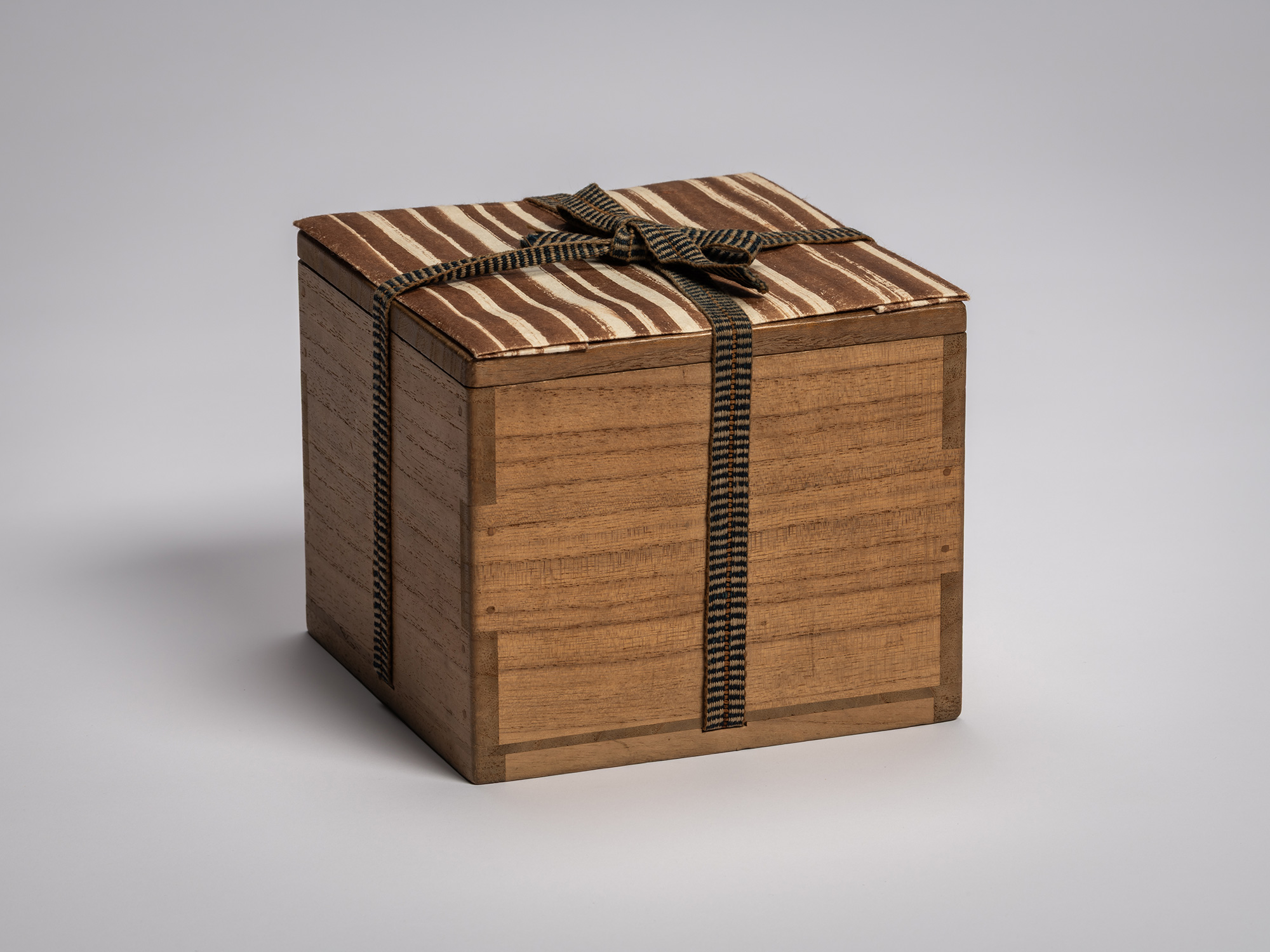 Interior wooden storage box for the tea bowl Yōbō Shungen by Raku IX, with a fitted lid wrapped...