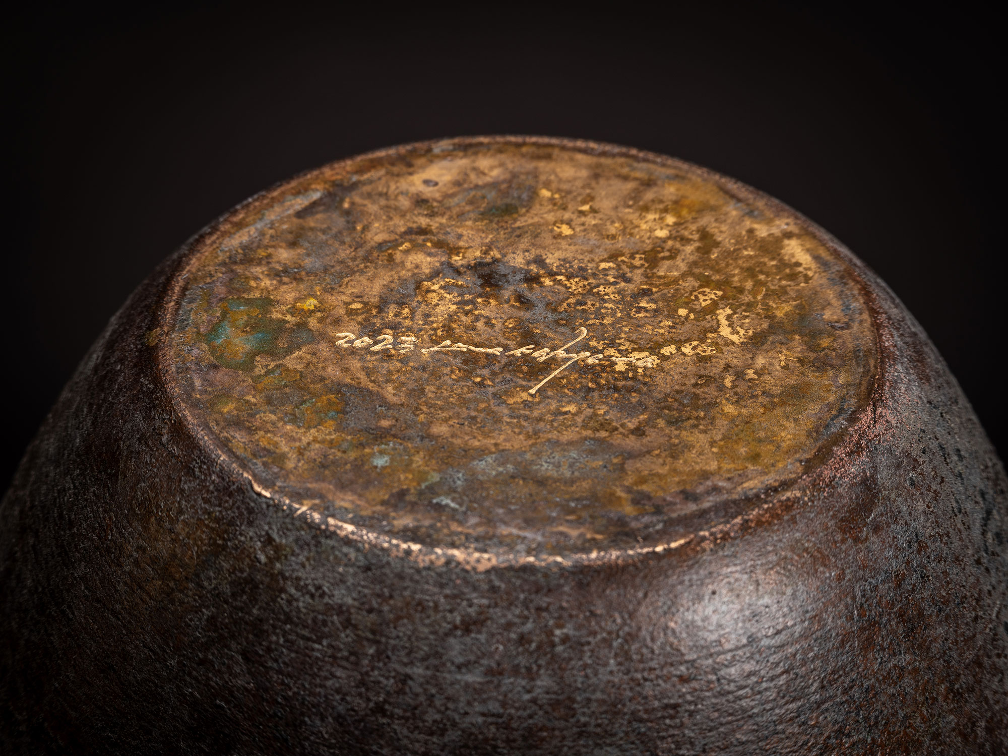 Underside view of a bronze vase by Koji Hatakeyama showing the circular base. The bottom surface...