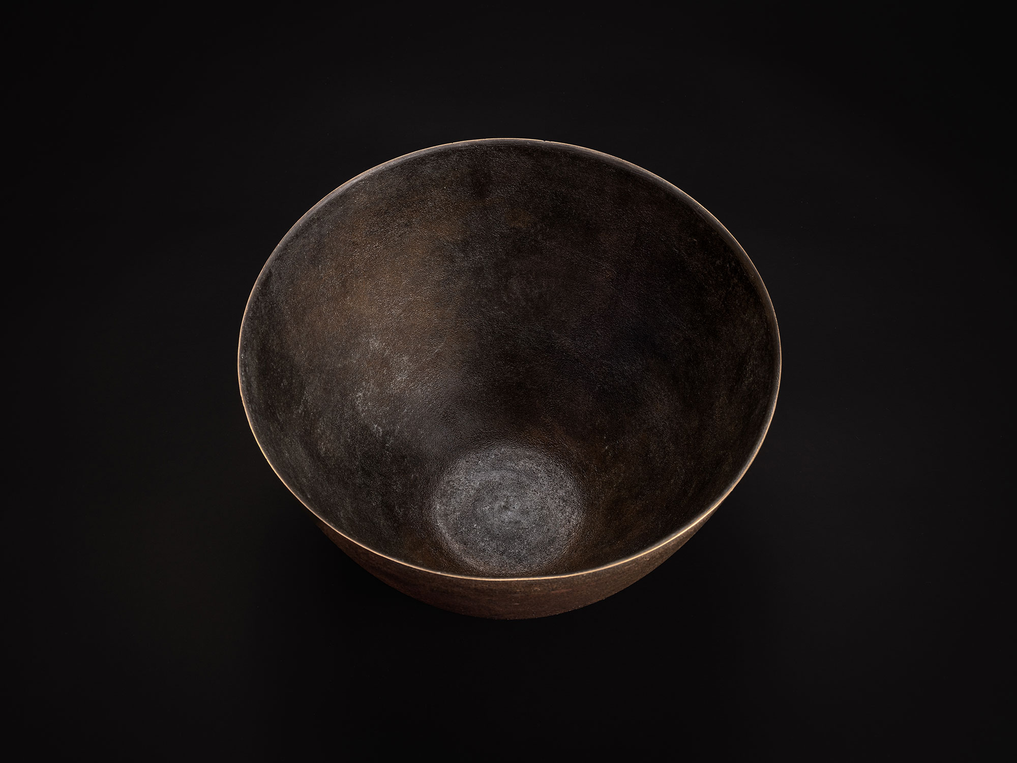 Aerial view of a bronze bowl by Koji Hatakeyama showing a wide circular opening and smooth, tapering...