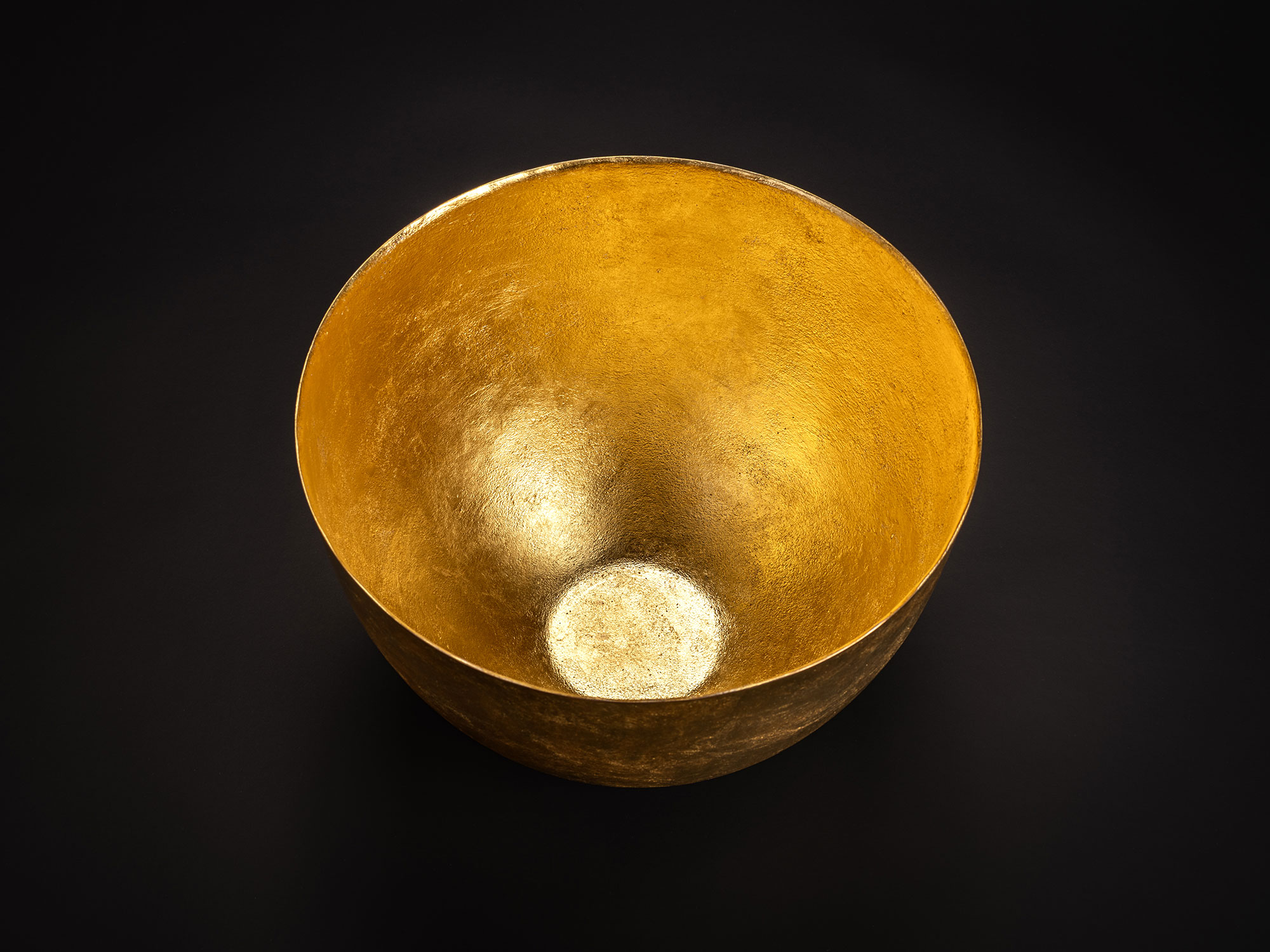 Aerial view of a bronze bowl by Koji Hatakeyama with a wide circular opening and gently sloping...