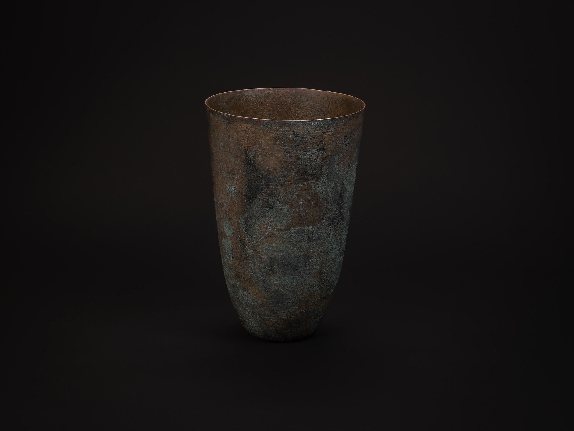 Tall cylindrical bronze vessel titled Bronze No. 1 by Hatakeyama, with a slightly flared rim and...