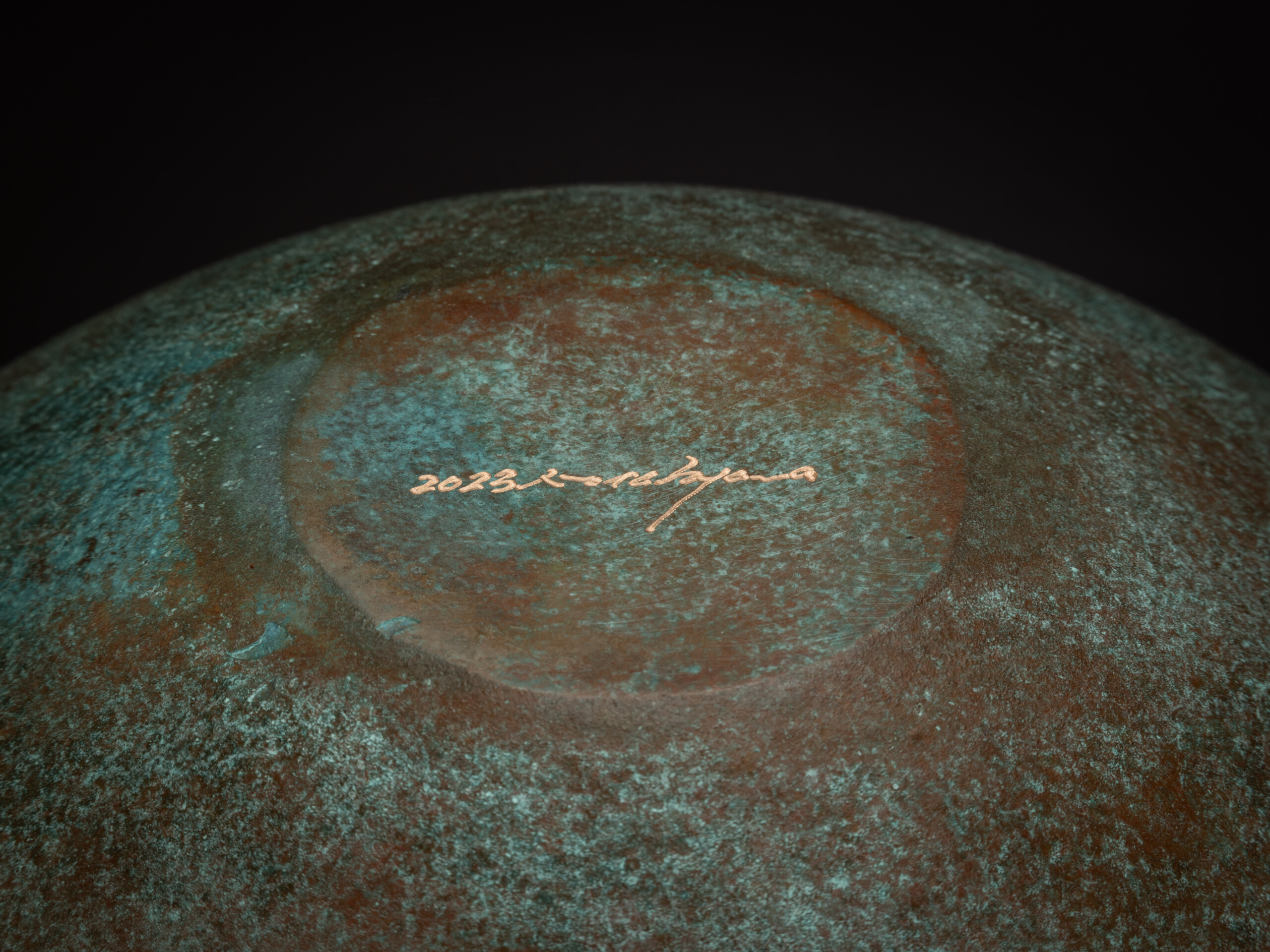 Underside view of Bronze No. 17 by Hatakeyama, showing a circular foot with a slightly raised edge...