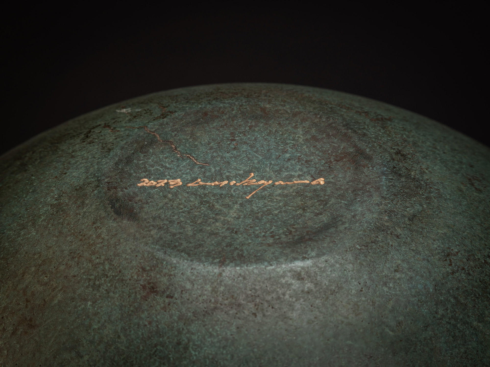 Underside view of Bronze No. 18 by Hatakeyama, showing a shallow, circular foot with a subtly raised...