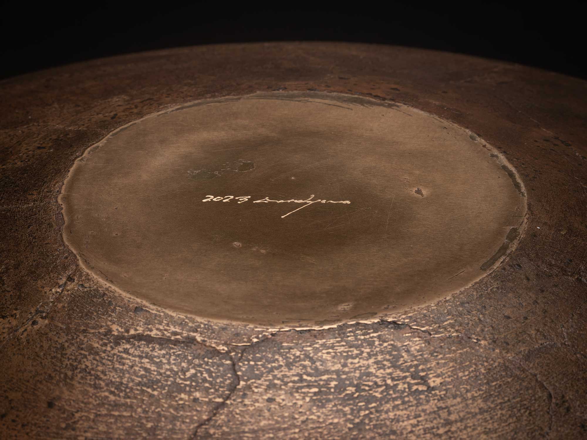 Underside of Bronze No. 21 by Hatakeyama, 2023, showing a circular polished foot encircled by a...