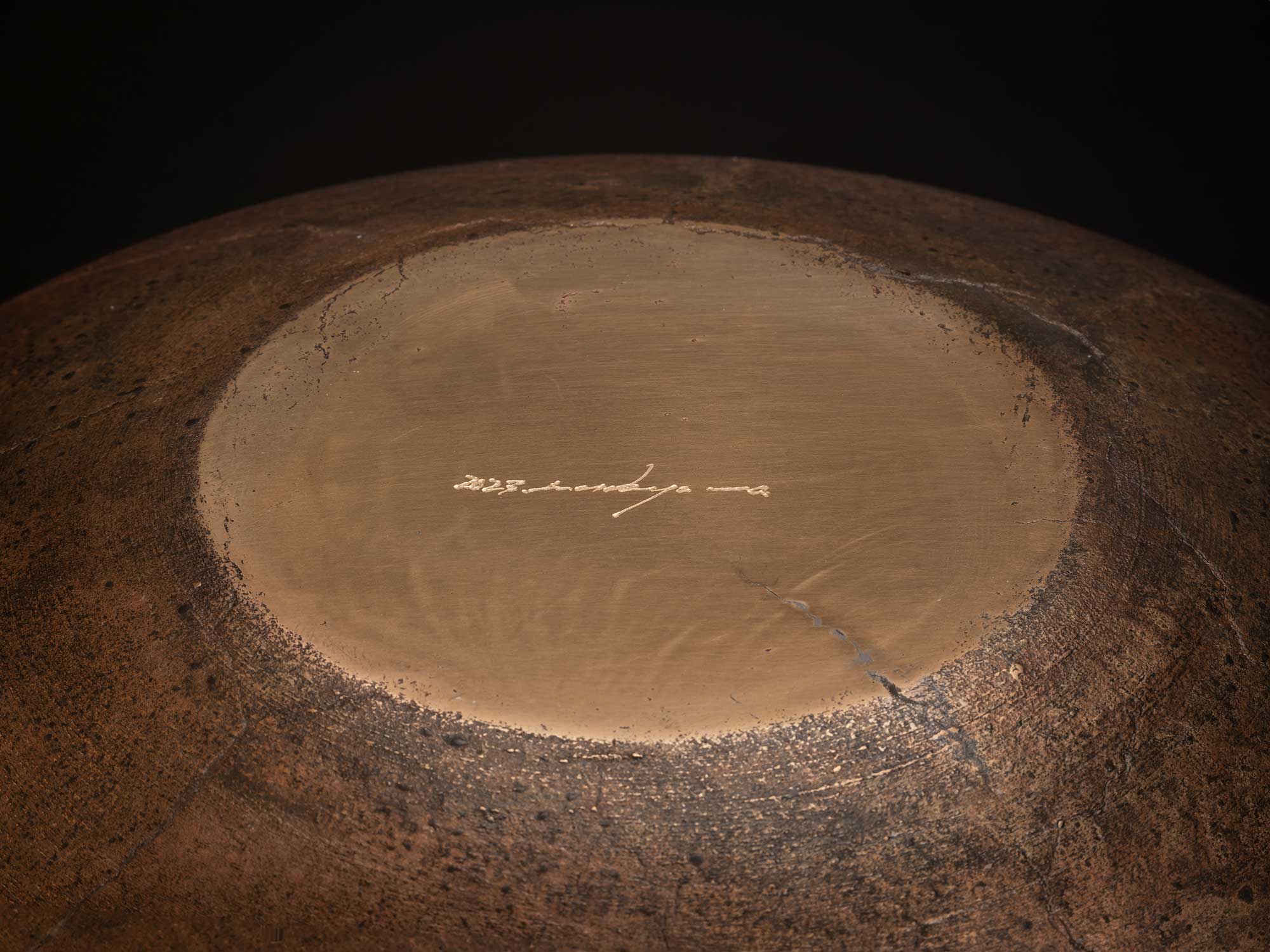 Underside of Bronze No. 22 by Hatakeyama, 2023, showing a circular polished foot surrounded by...