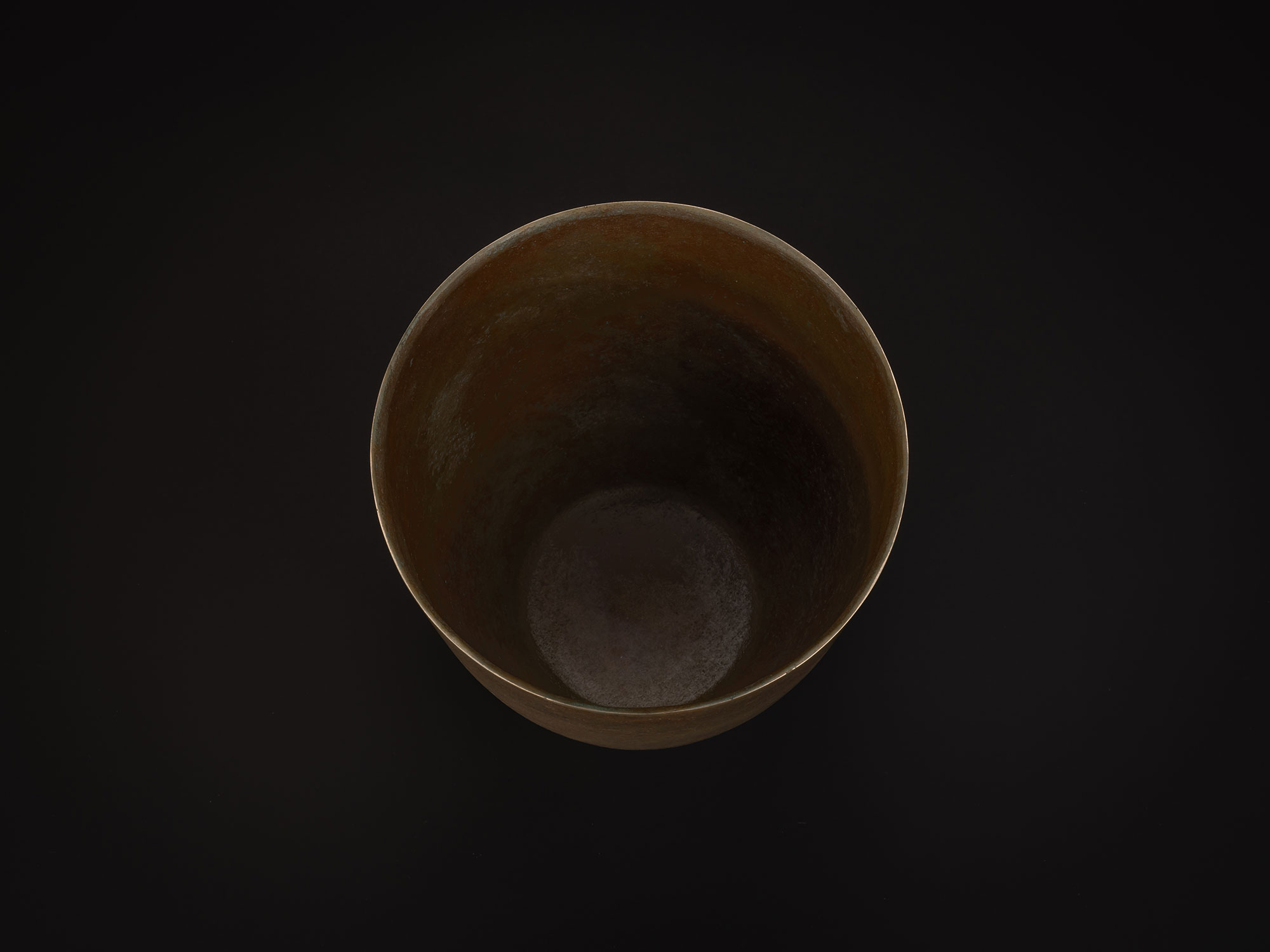 Aerial view of a bronze vessel by Koji Hatakeyama showing a wide circular opening and tall interior...