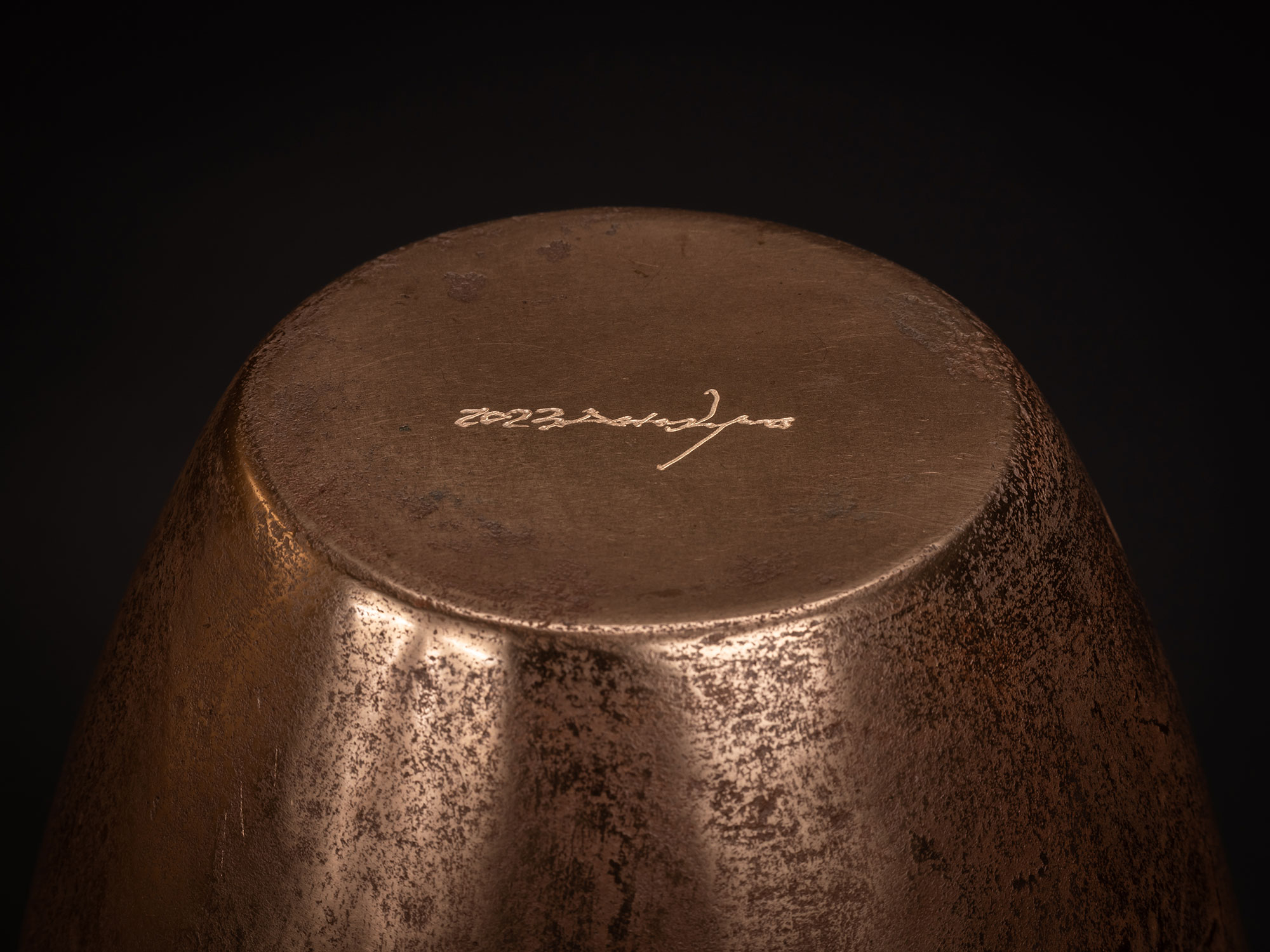 Base of Bronze No. 13 by Koji Hatakeyama, showing the underside of the bronze vessel with a warm...