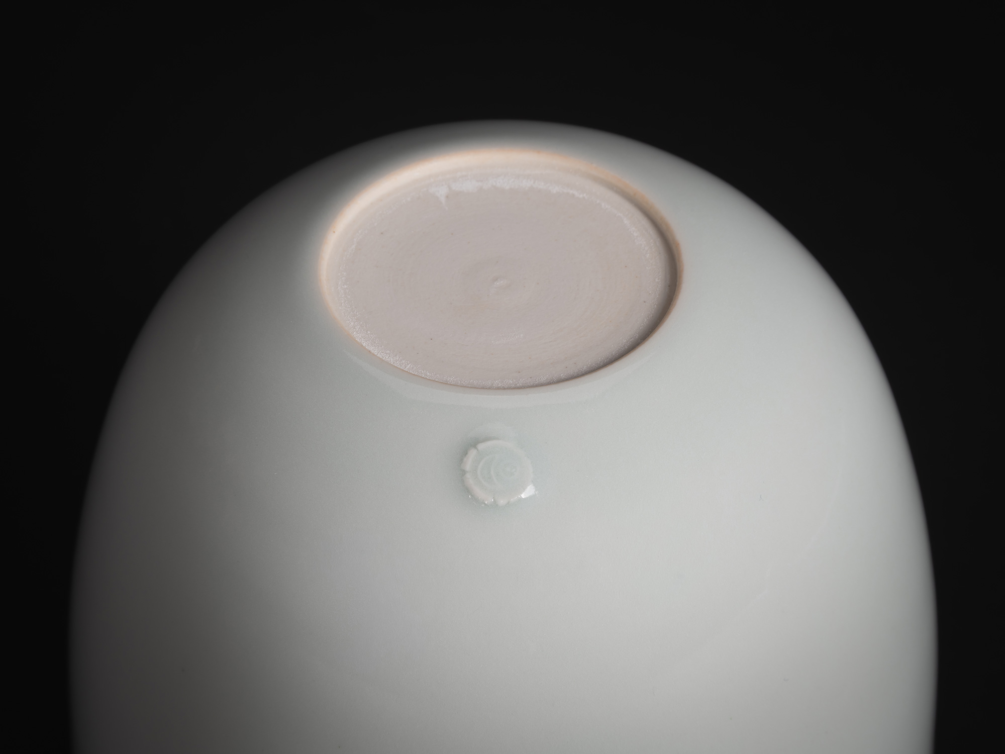 A macro, close-up photograph of the base of a porcelain vessel from the Nesting Covered Boxes series...