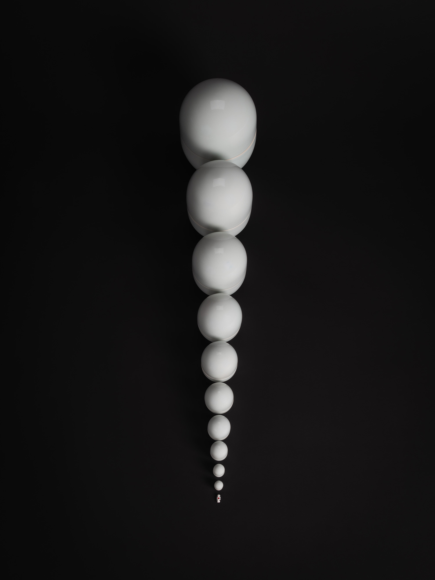 A striking overhead, vertical photograph of the ceramic installation Nesting Covered Boxes by Akira...