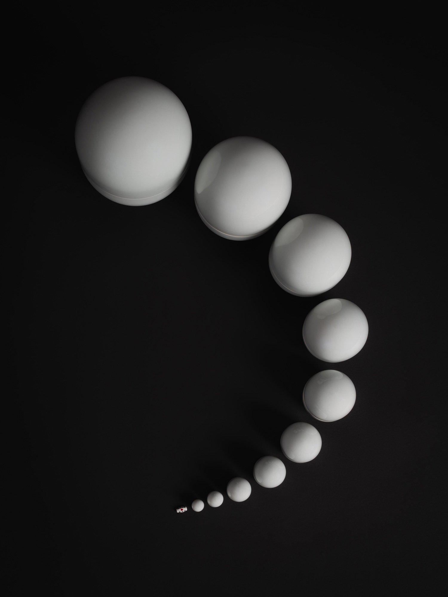 A minimalist, bird's-eye view photograph of the contemporary ceramic artwork Nesting Covered Boxes...