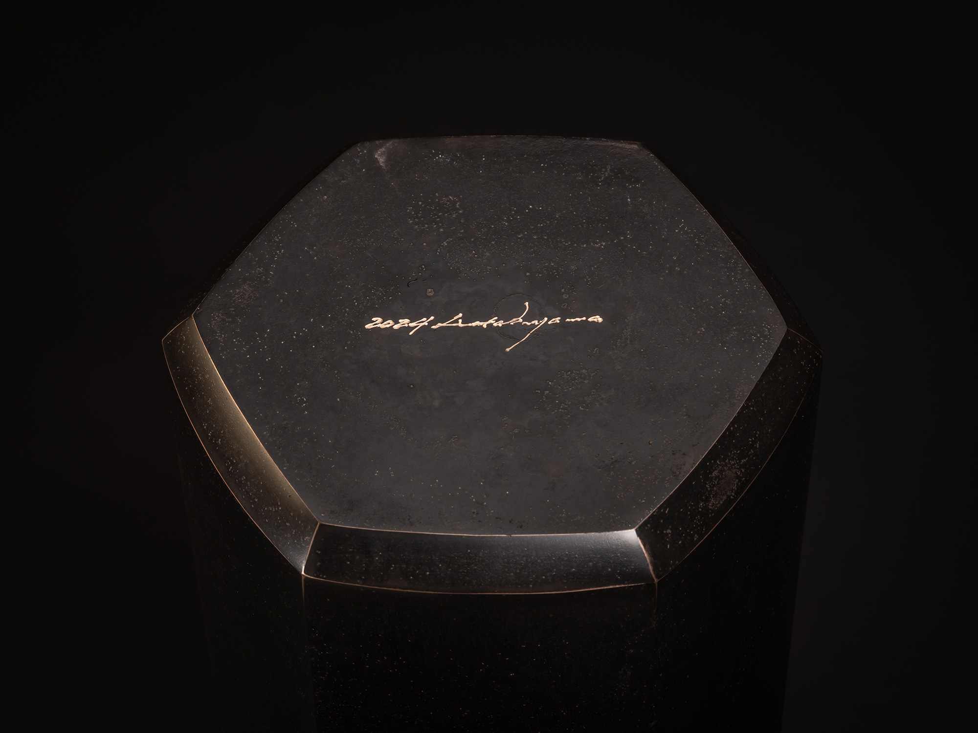 Koji Hatakeyama, Six Faces, 2024. Close-up of the hexagonal top surface of a faceted bronze vessel,...