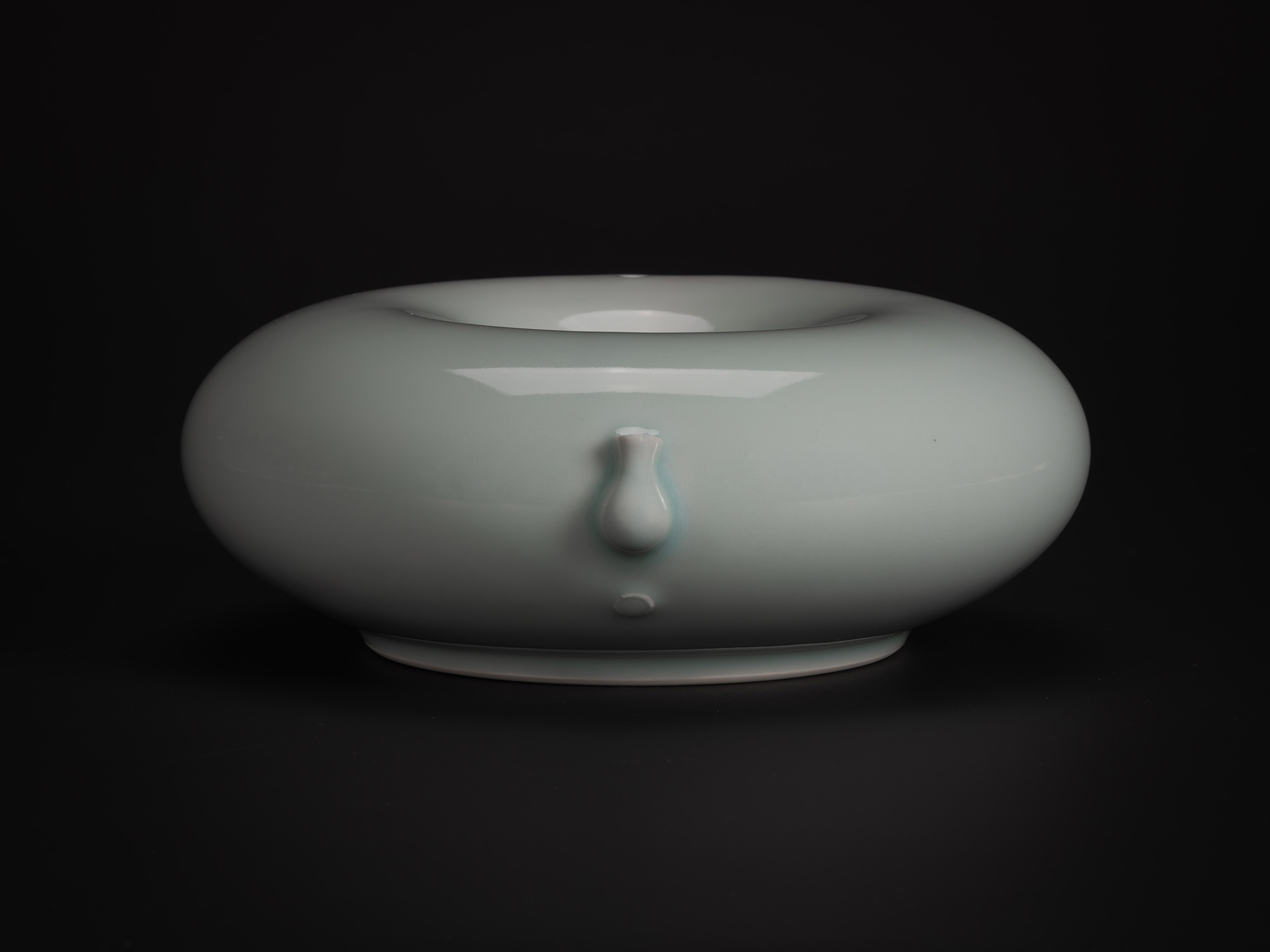 A profile studio photograph of a ceramic water dropper (suiteki) by Japanese artist Akira Yagi....