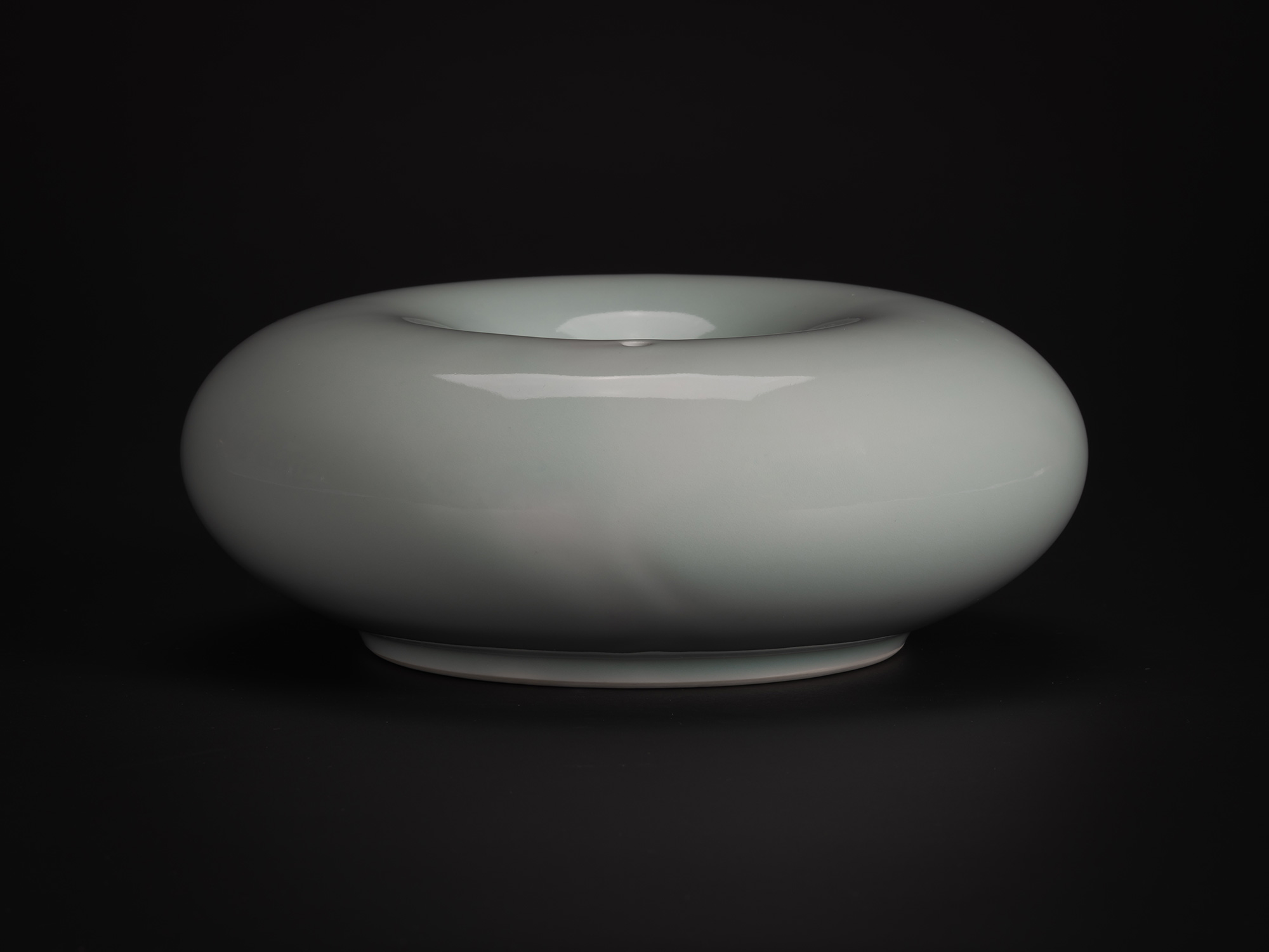 A side-profile photograph of the Water Dropper (suiteki) by Japanese ceramic artist Akira Yagi....