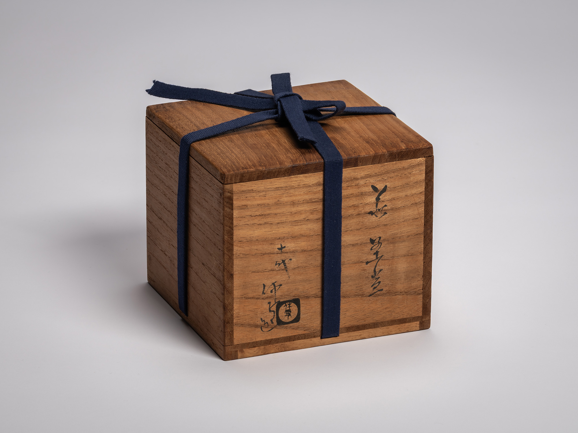 Tomobako (wooden storage box) for a Hagi chawan by Miwa X, a warm-toned wood box with black calligraphy...