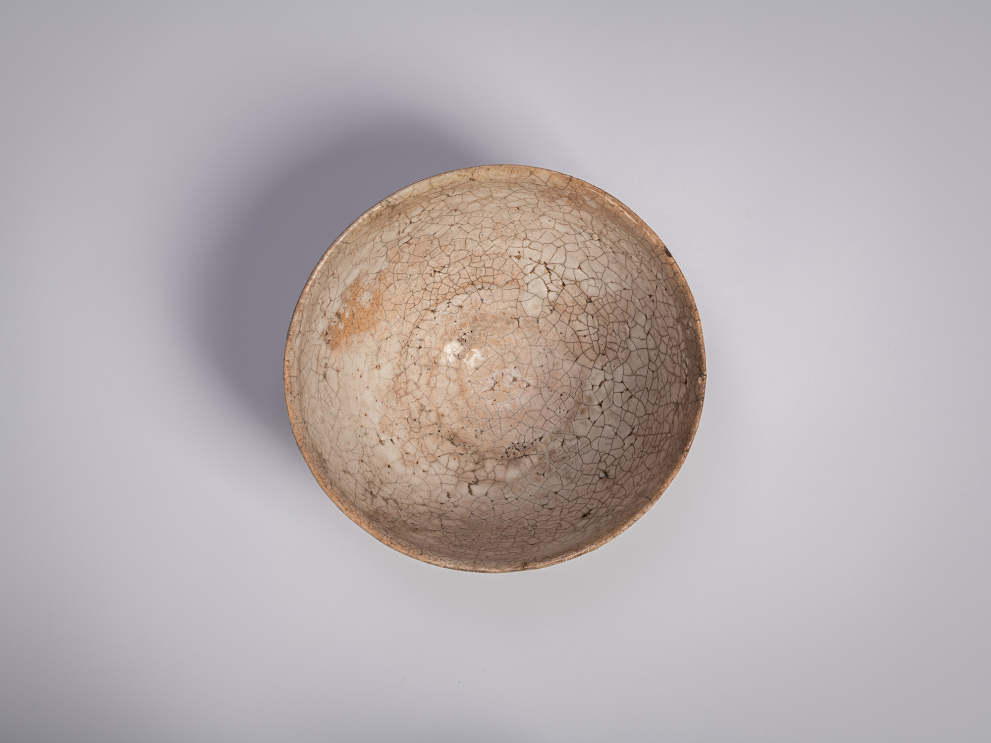Interior of an Ido chawan by Tsujimura, showing a rounded bowl form with a creamy glaze and a dense...
