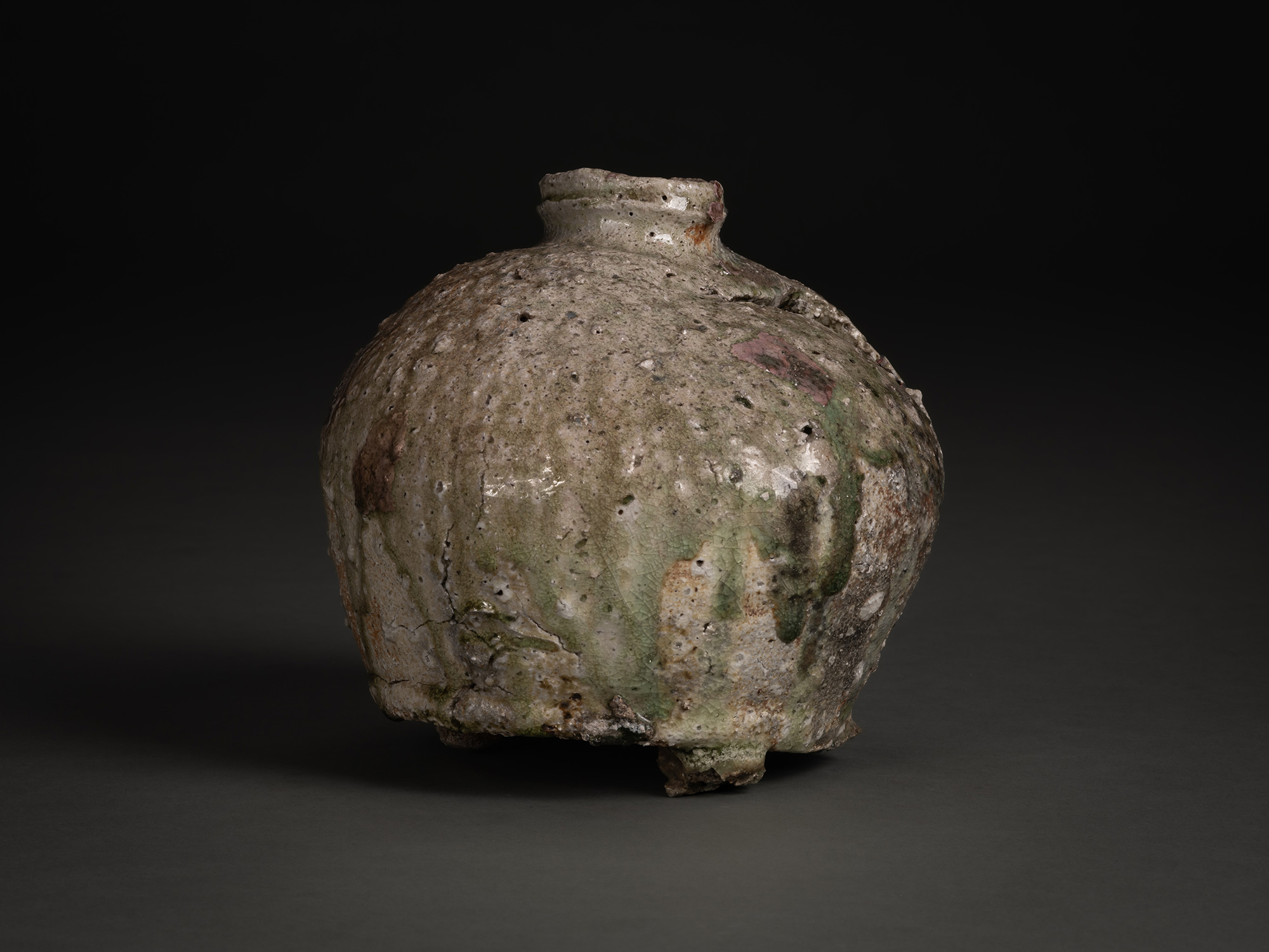 Side view of Iga Broken Jar by Shiro Tsujimura, a rounded ceramic vessel with a narrow neck and...
