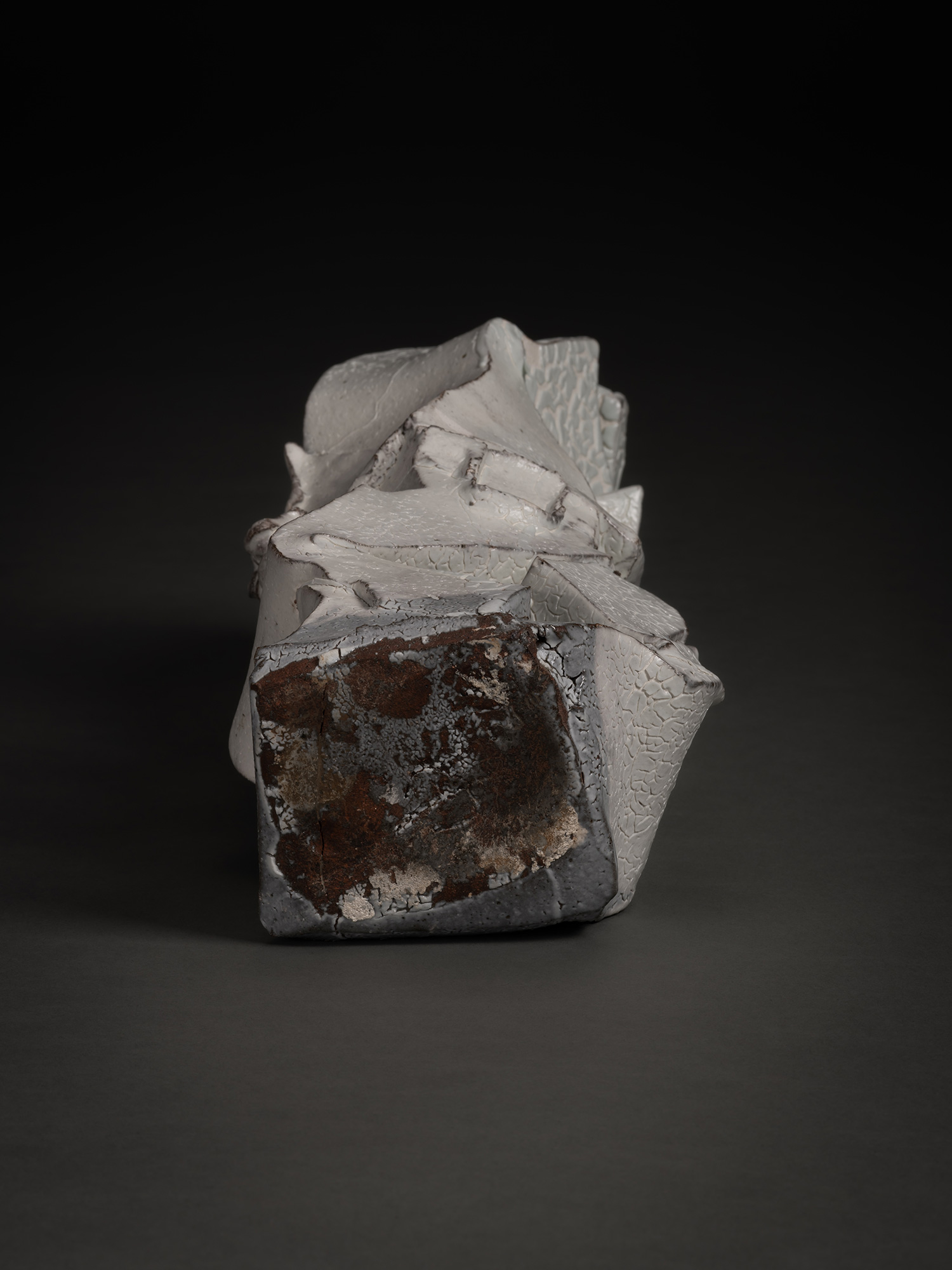 A close-up view of the unglazed base of Shozo Michikawa's Kohiki Sculptural Form. The square-shaped...