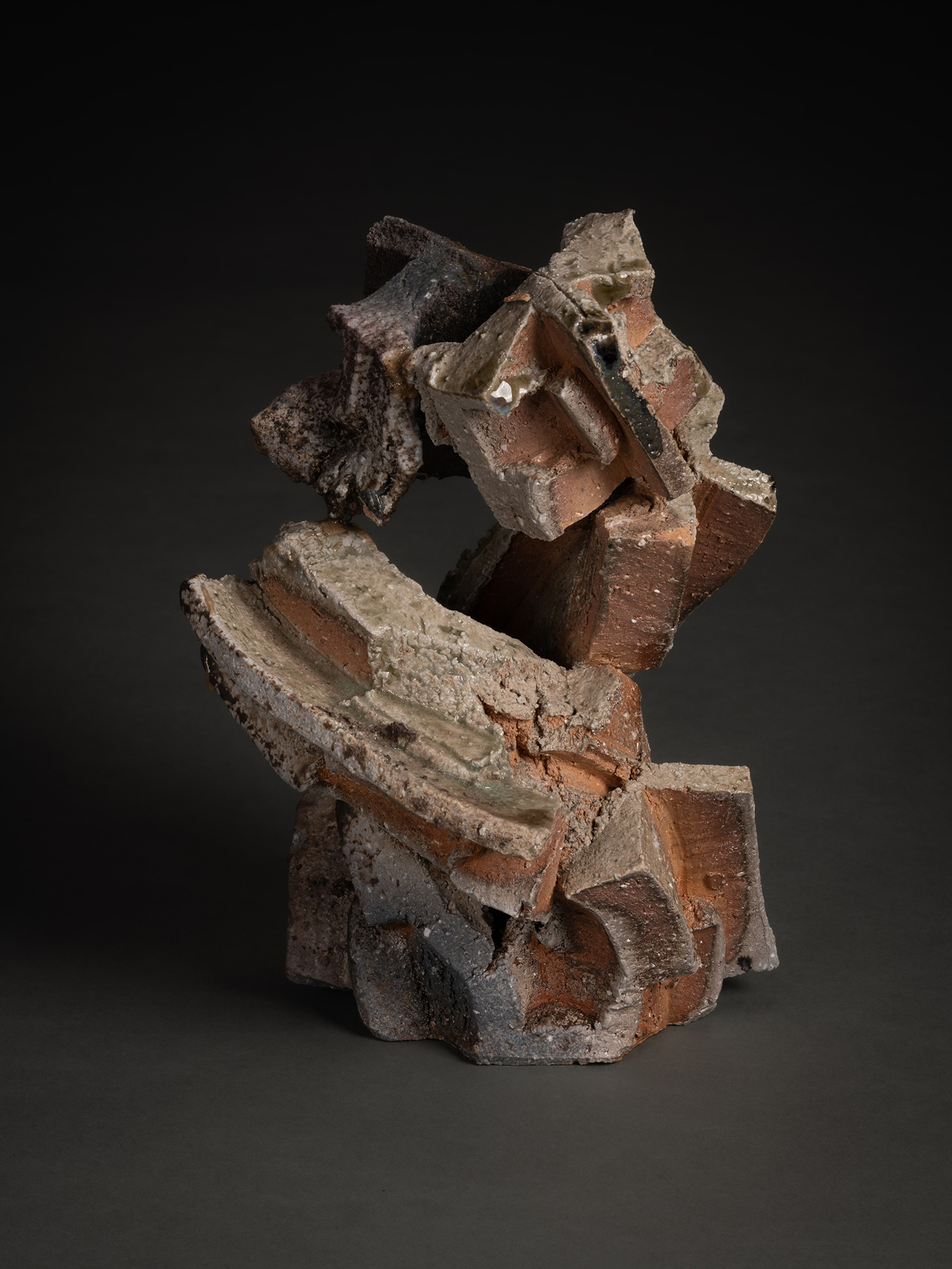 A vertical, multi-layered stoneware sculpture by Shozo Michikawa featuring a stack of sharp, protruding...