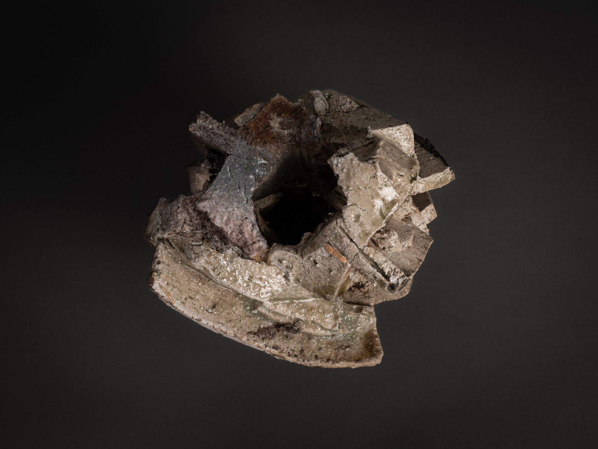 An overhead aerial view looking down into the hollow, dark core of a Shozo Michikawa sculpture....