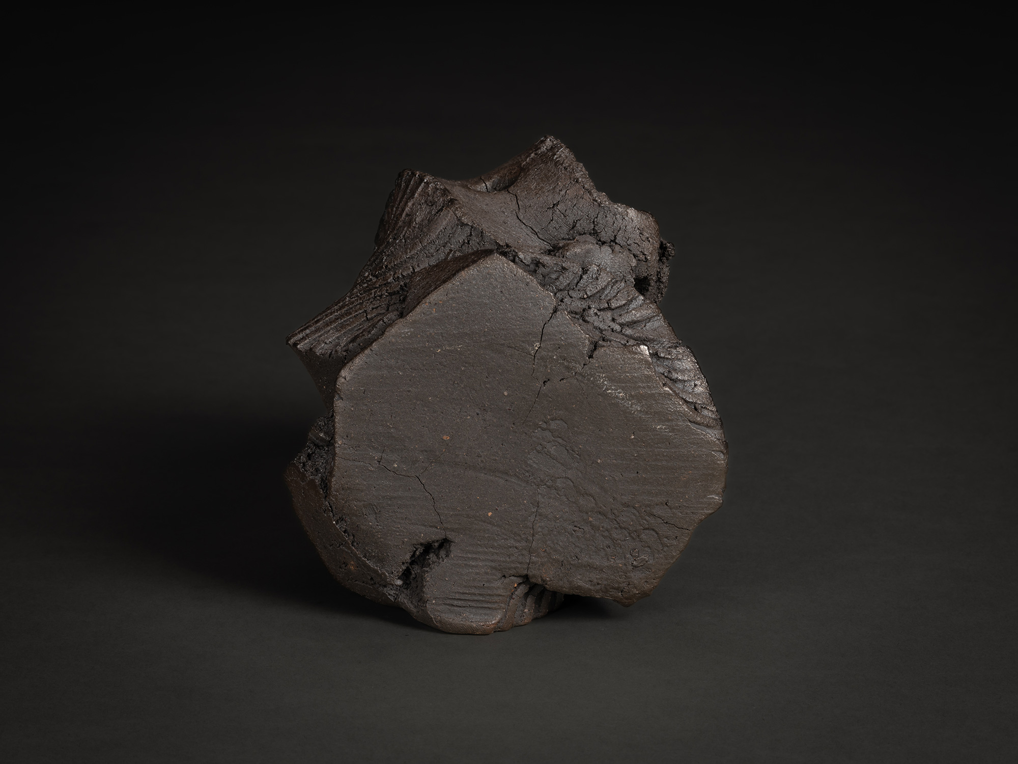 Side view of a rugged sculptural form by Shozo Michikawa. The piece is characterized by a massive,...