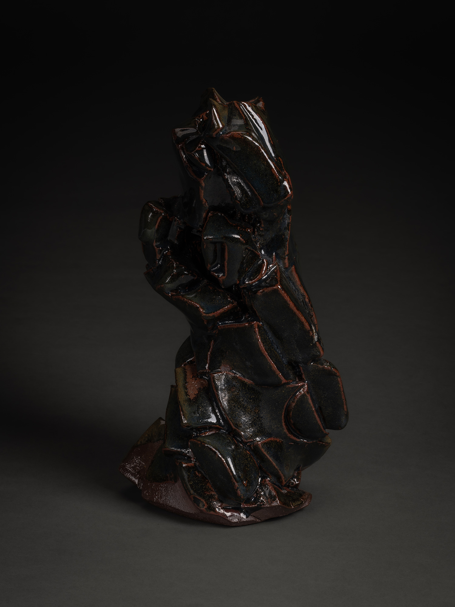A vertical, side-profile view of a ceramic sculpture by Shozo Michikawa. The work features a jagged,...