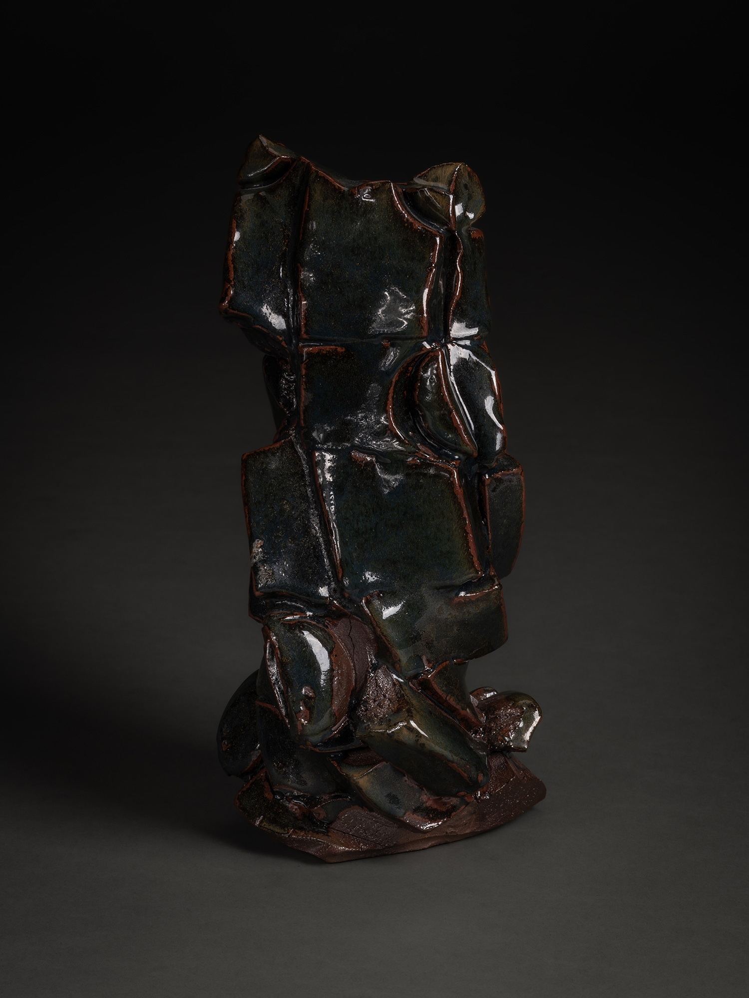 A vertical, side-profile view of a ceramic sculpture by Shozo Michikawa. The work features a jagged,...