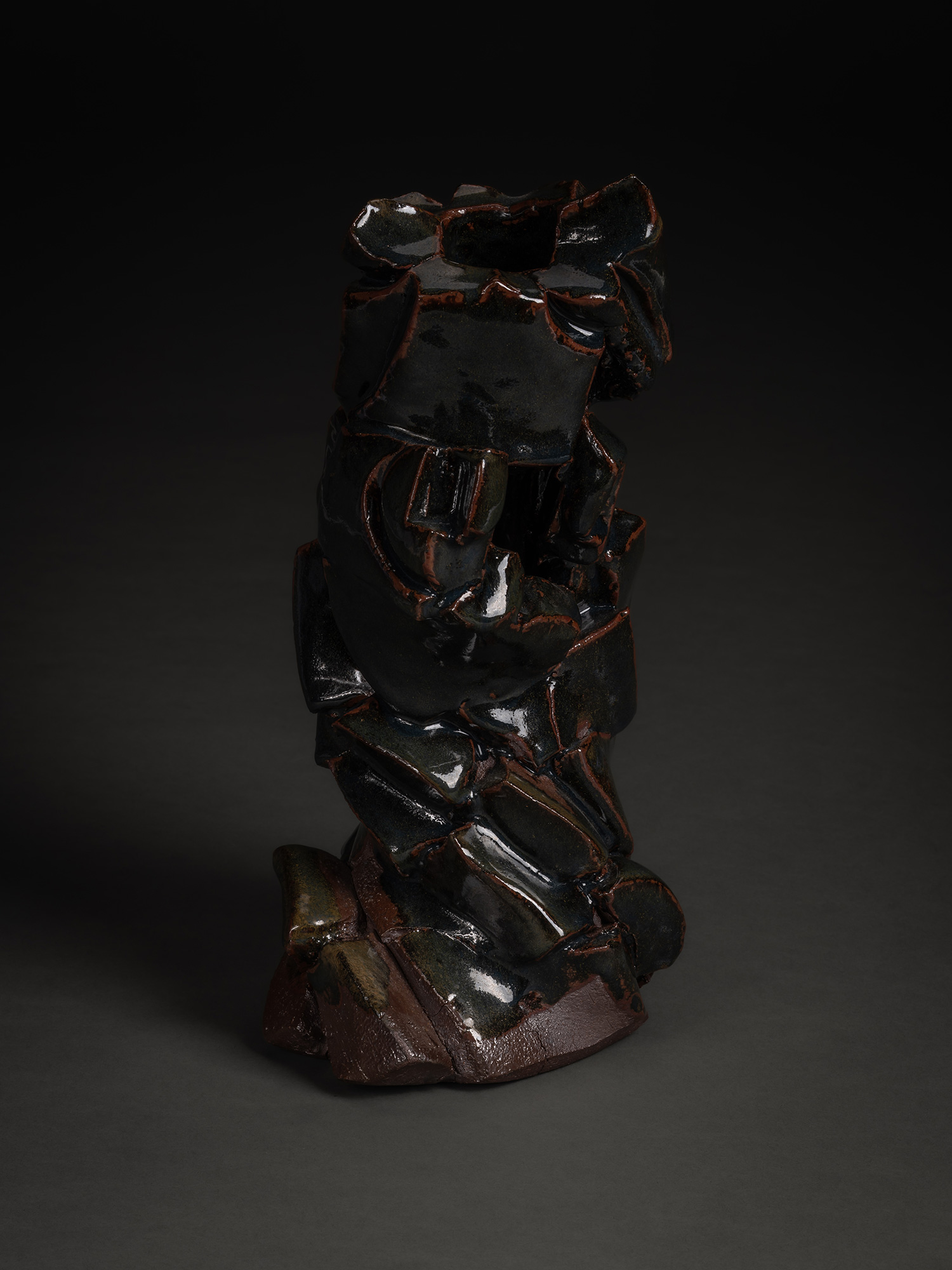 A vertical, side-profile view of a ceramic sculpture by Shozo Michikawa. The work features a jagged,...