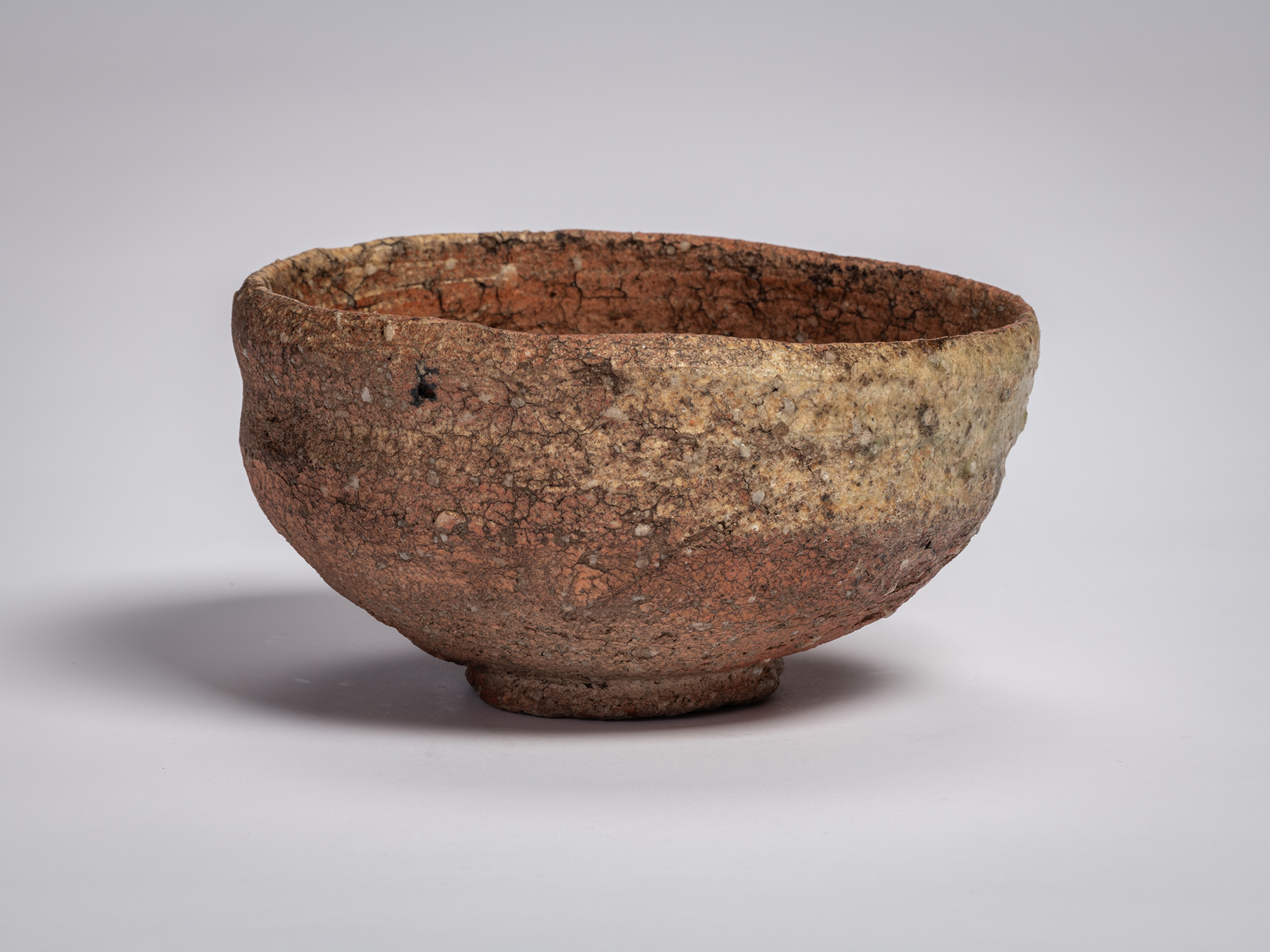 Shigaraki chawan tea bowl by Tsujimura, with a low, rounded form, rough granular clay body, and...