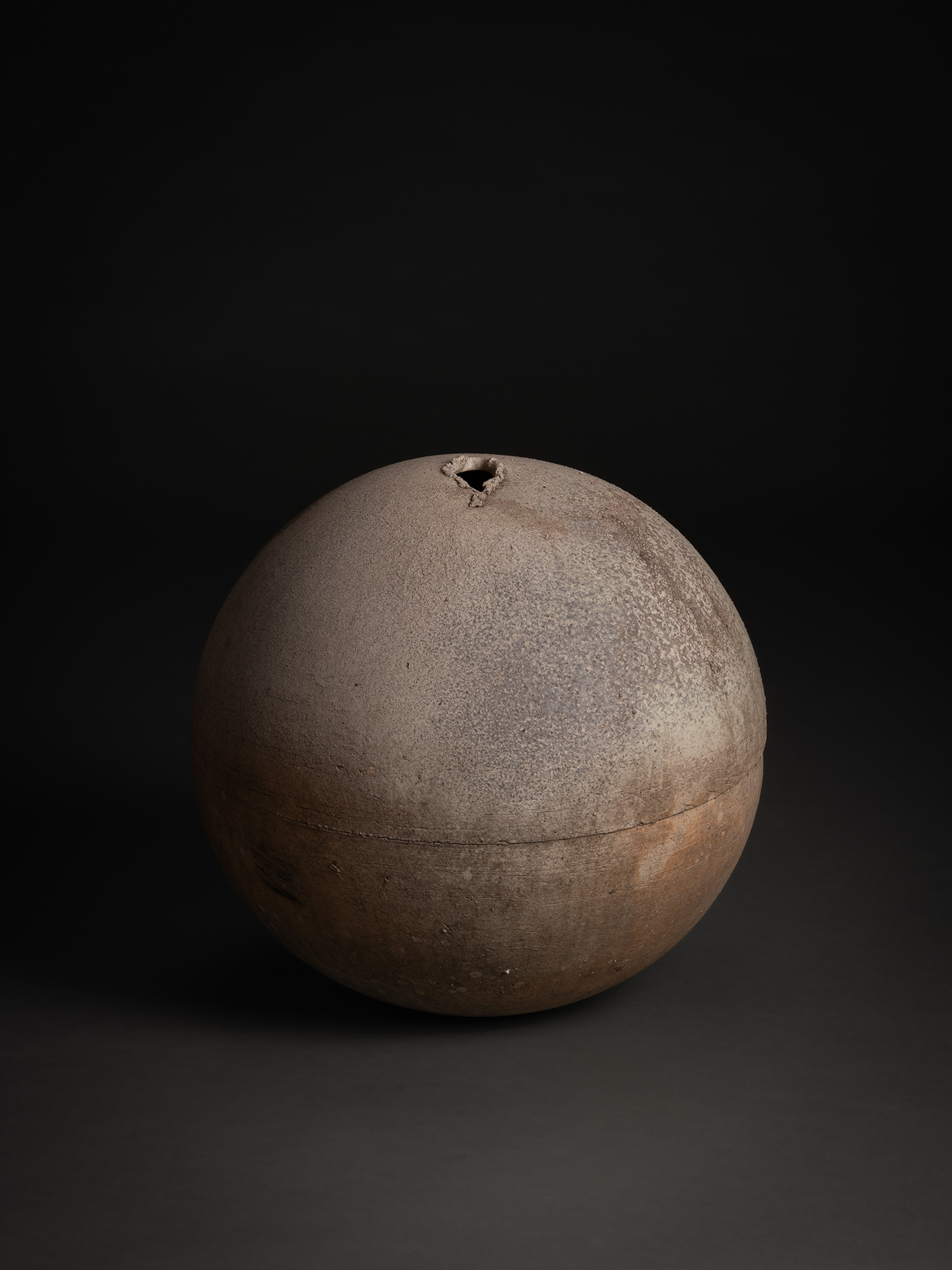 Sphere by Tsujimura, a rounded ceramic form with a near-perfect spherical silhouette, shown against...