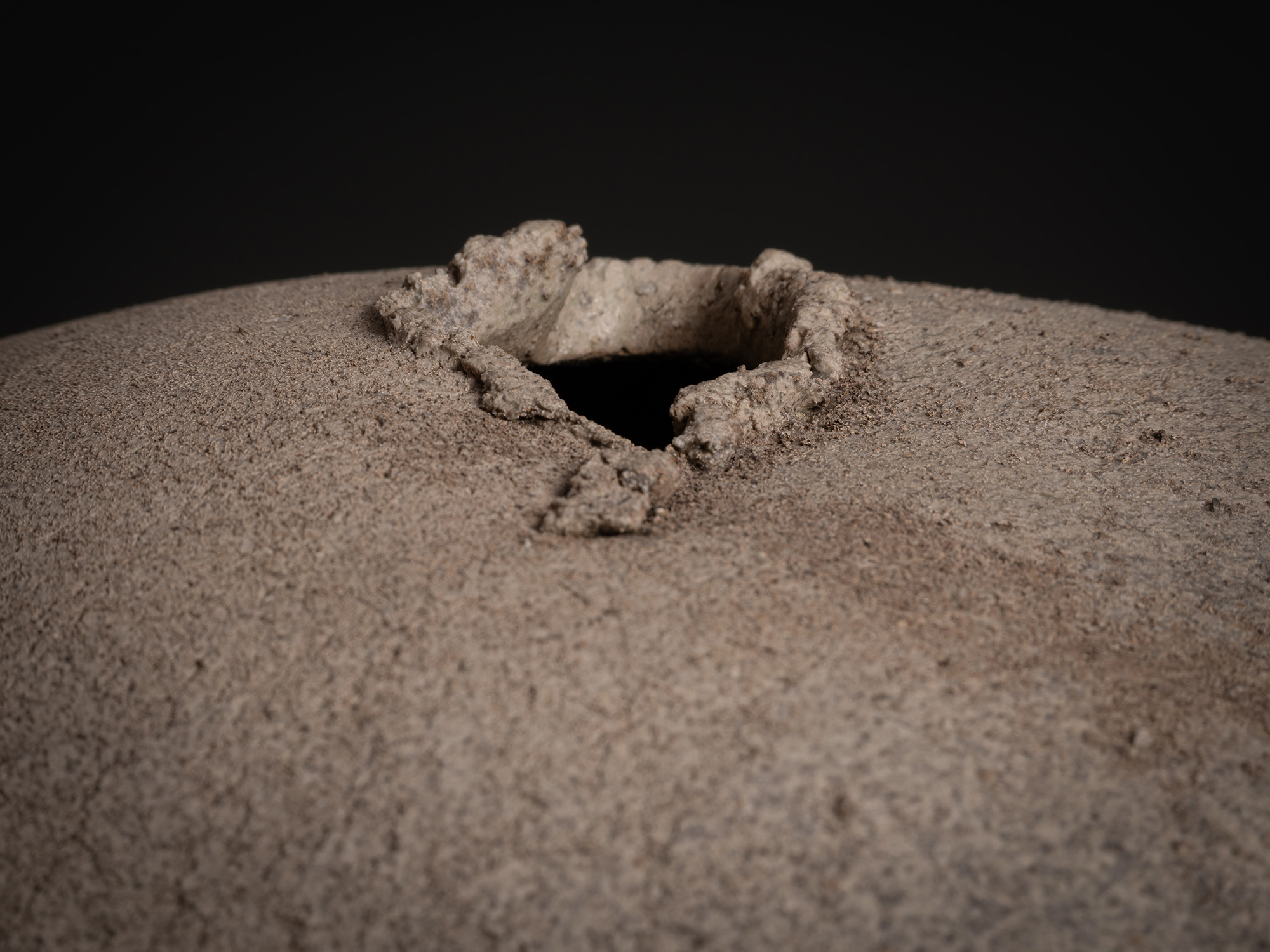 Detail of Sphere by Tsujimura showing the top opening: a small, irregularly shaped aperture with...