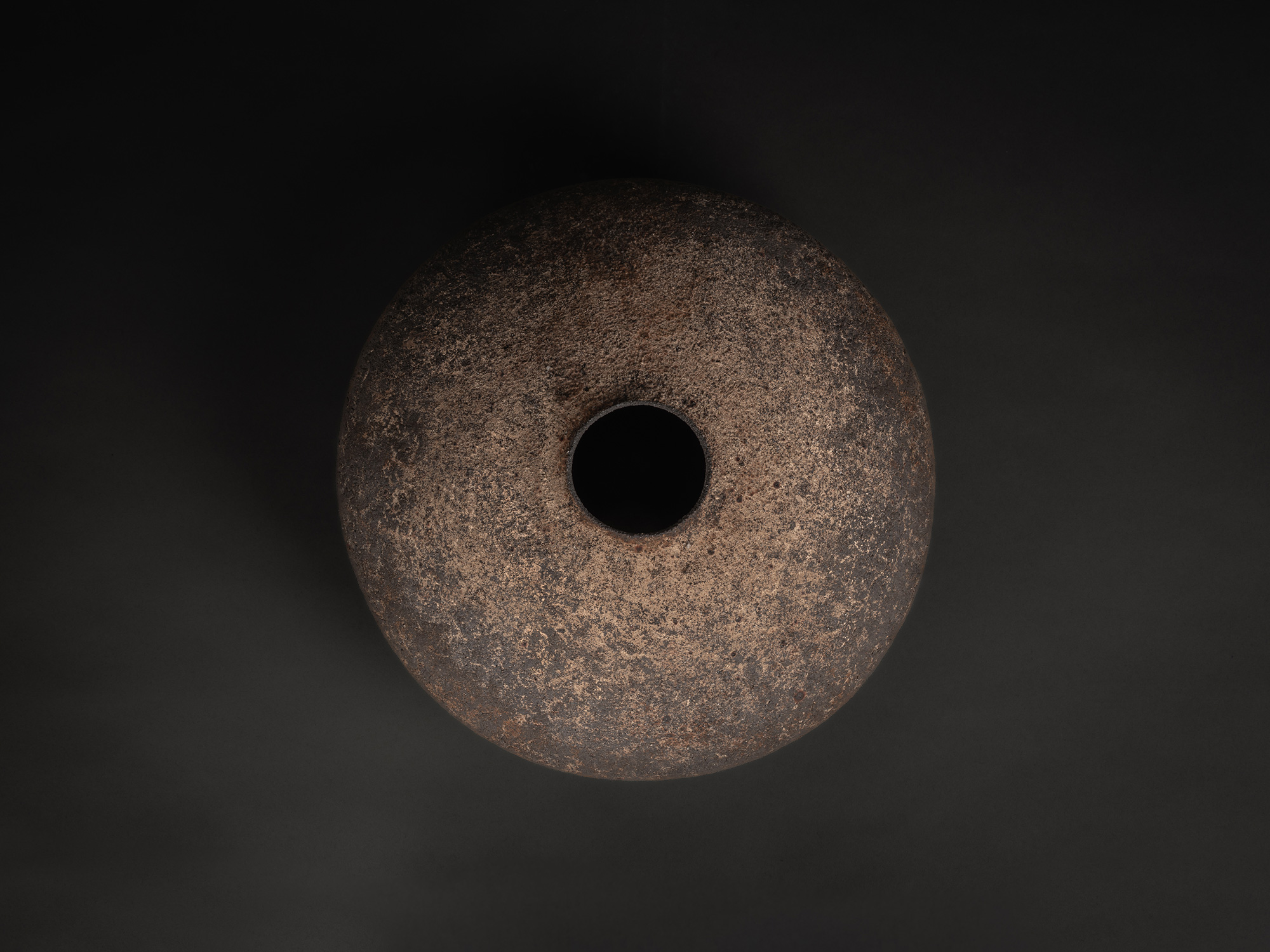 Aerial view of a vase by Jun Aoki, showing a flattened, circular form with a small central opening,...