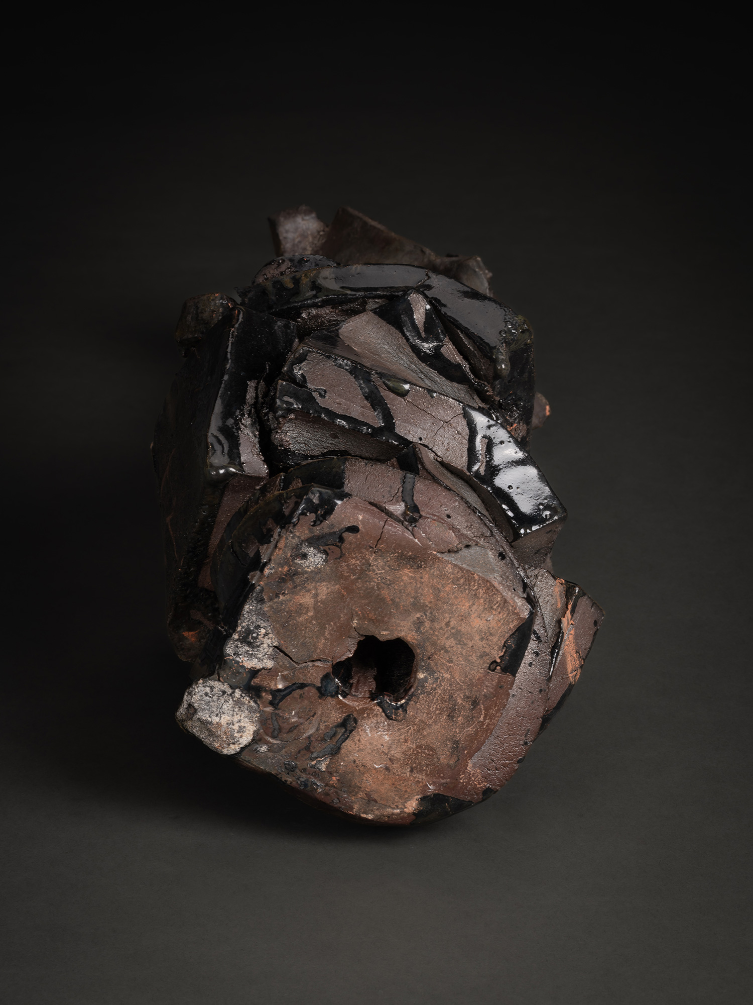 .Foot of Volcano by Michikawa, showing a rough, circular base with a central opening, exposed clay,...
