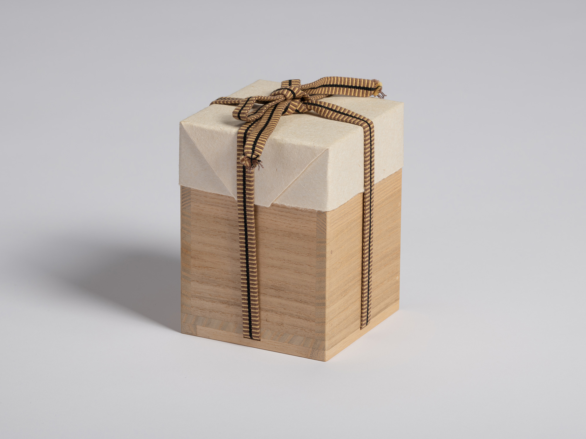 Tomobako storage box for a black guinomi by Ryuichi Kakurezaki wrapped in protective white paper...