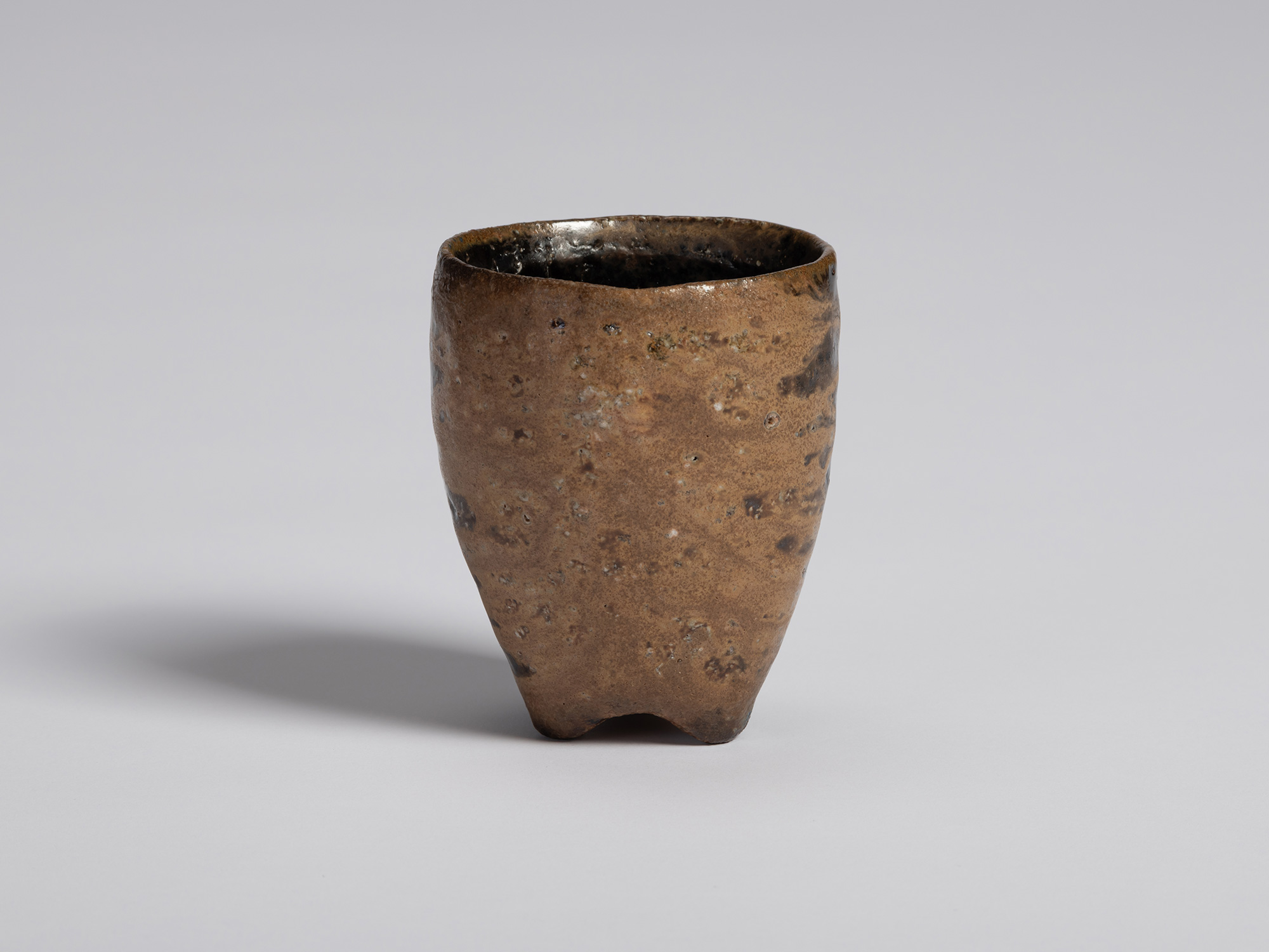 Black guinomi by Ryuichi Kakurezaki shown from an exterior view emphasizing the raw clay body....