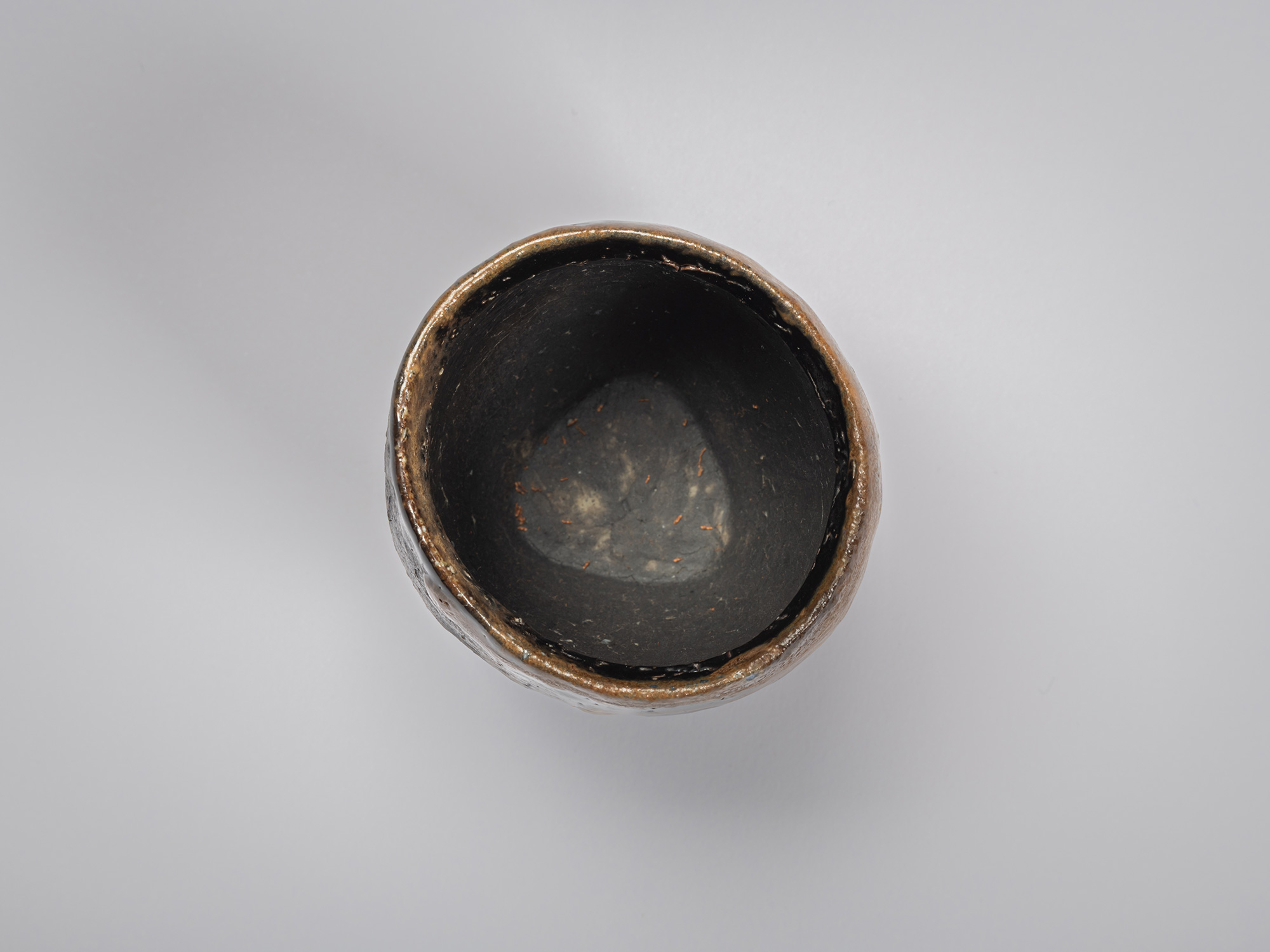 Aerial interior view of a black guinomi by Ryuichi Kakurezaki showing a deep cylindrical interior...