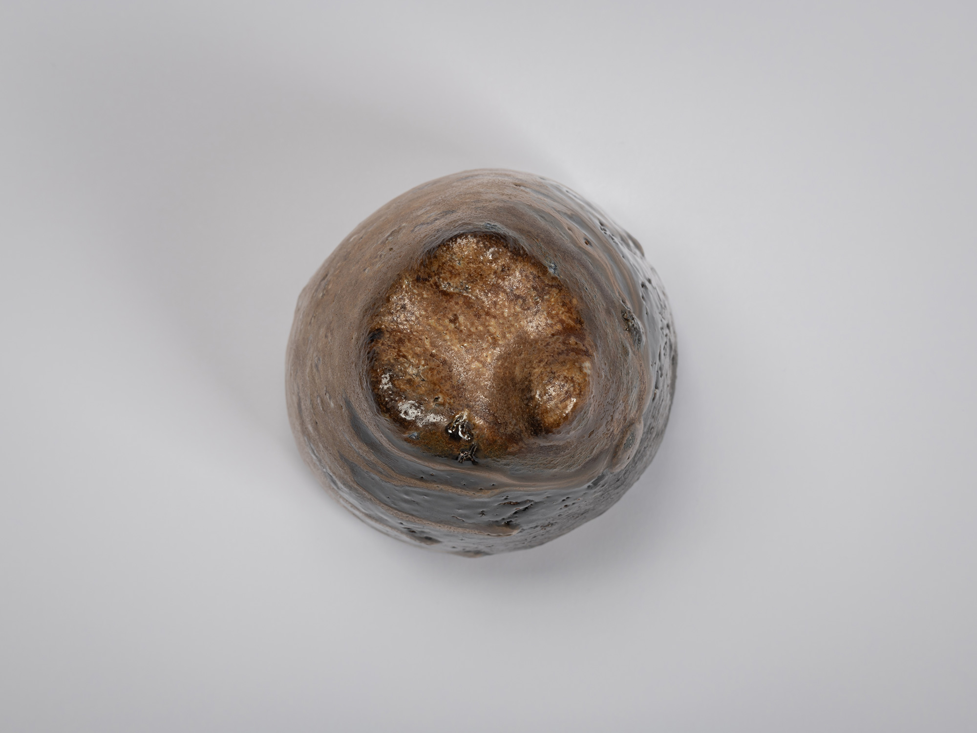 Foot view of a black guinomi by Ryuichi Kakurezaki showing a triangular recessed base with three...