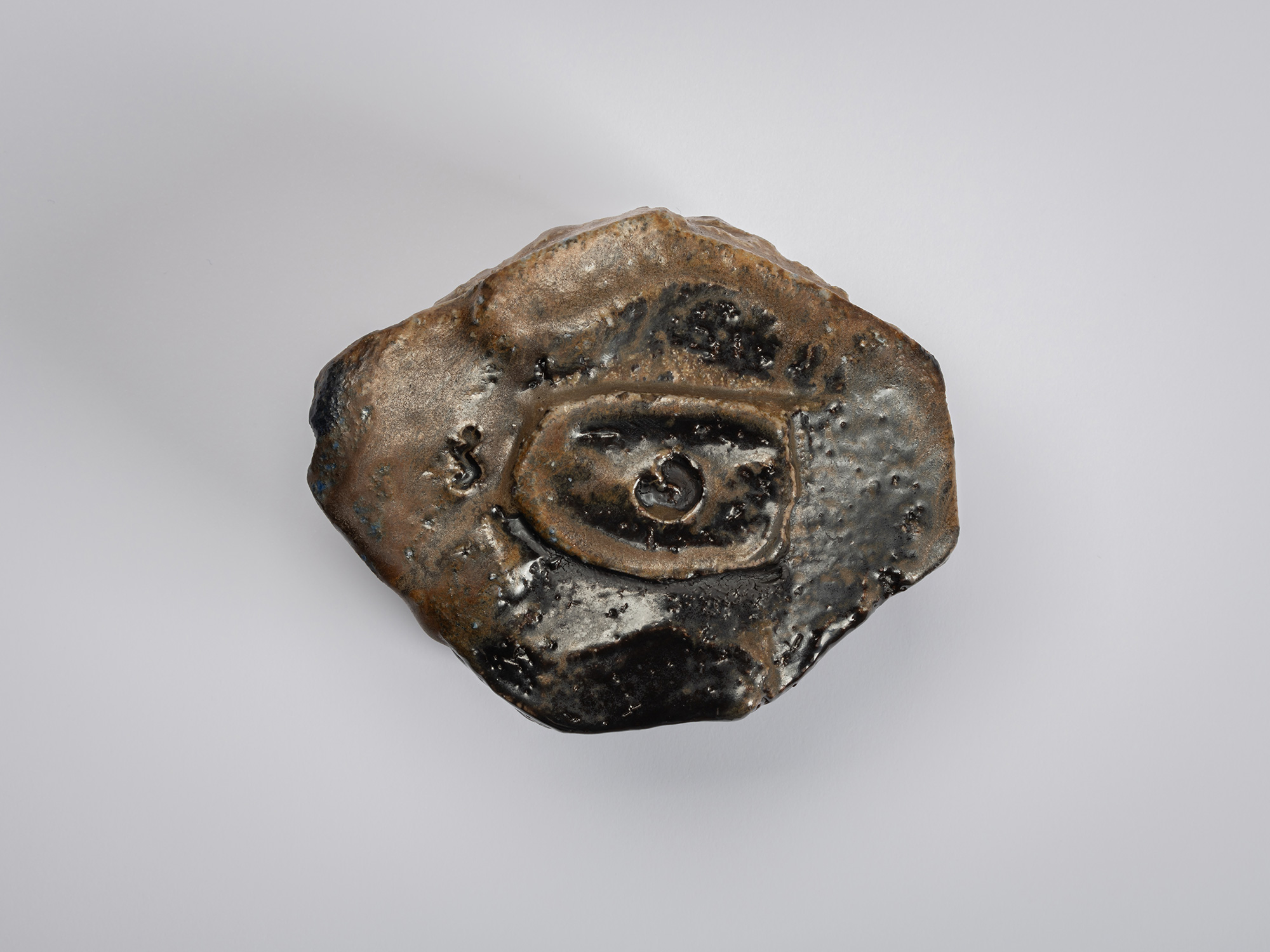 Aerial foot view of a black tea bowl by Ryuichi Kakurezaki revealing an uneven polygonal base with...